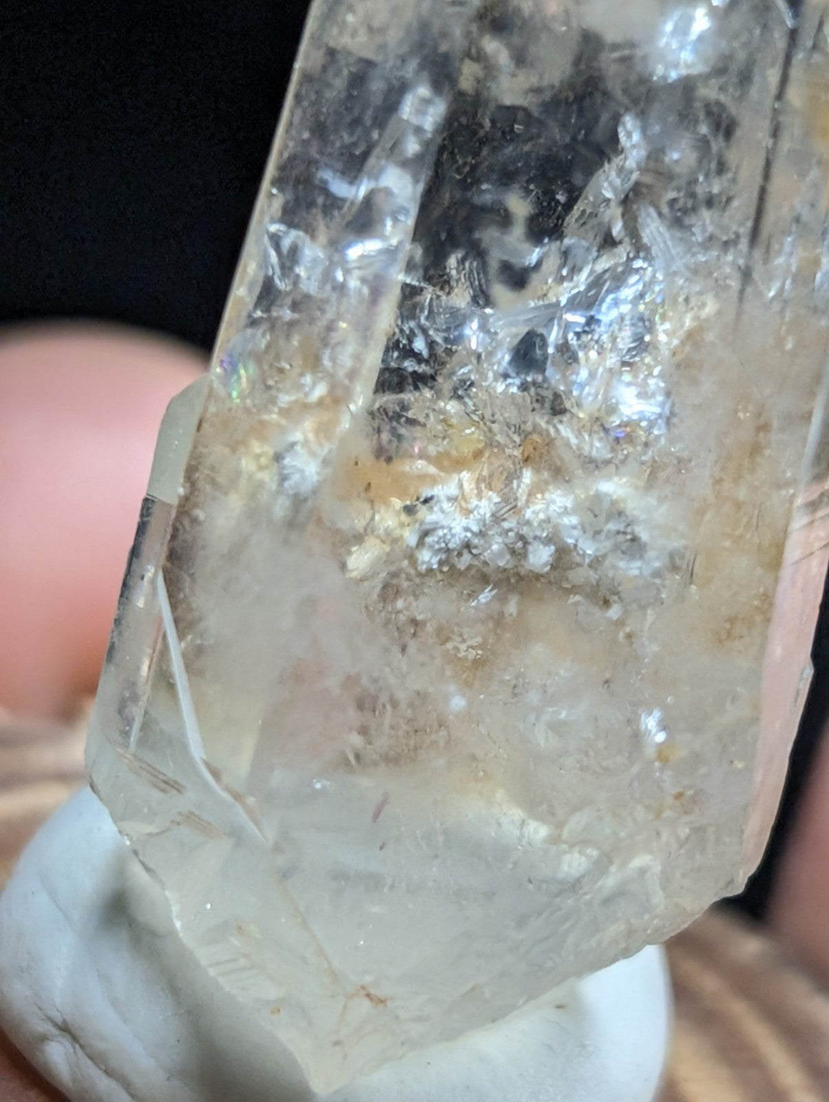 A translucent, clear quartz crystal with natural inclusions and subtle golden-brown veining.