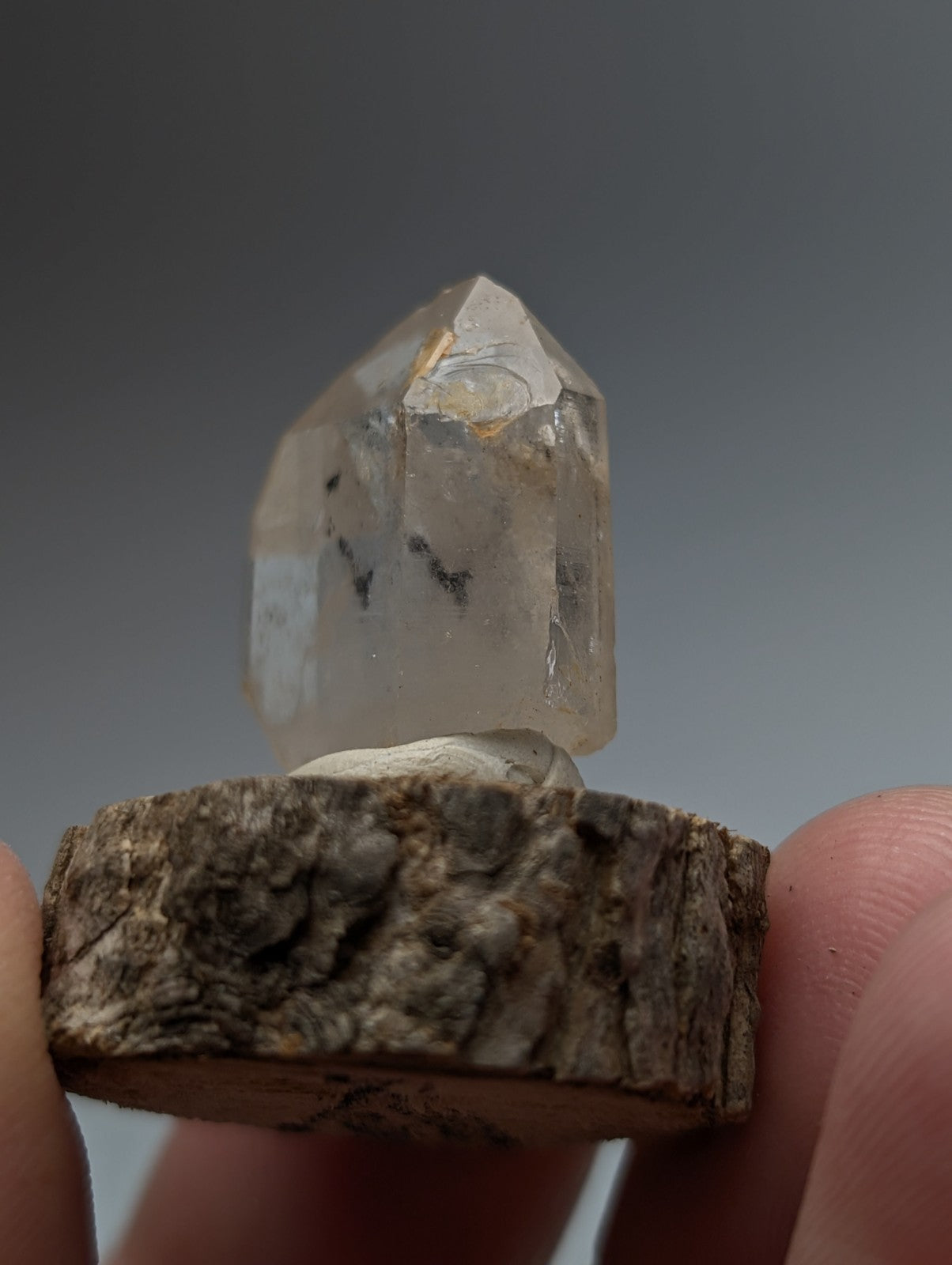 Nacrite manganese included quartz crystal point with subtle inclusions on a rustic wooden base from Arkansas
