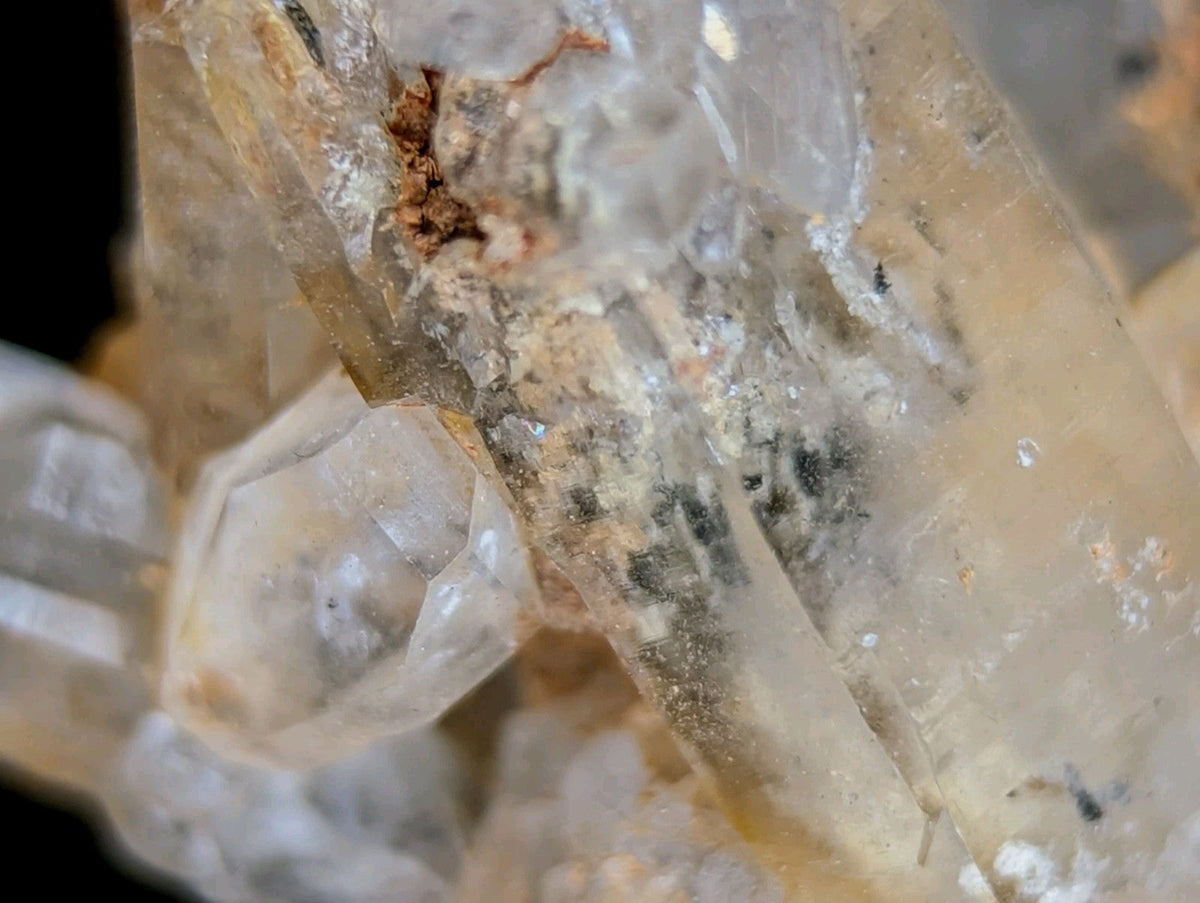 A cluster of translucent, pale yellow quartz crystals with subtle internal inclusions and a slightly cloudy appearance.