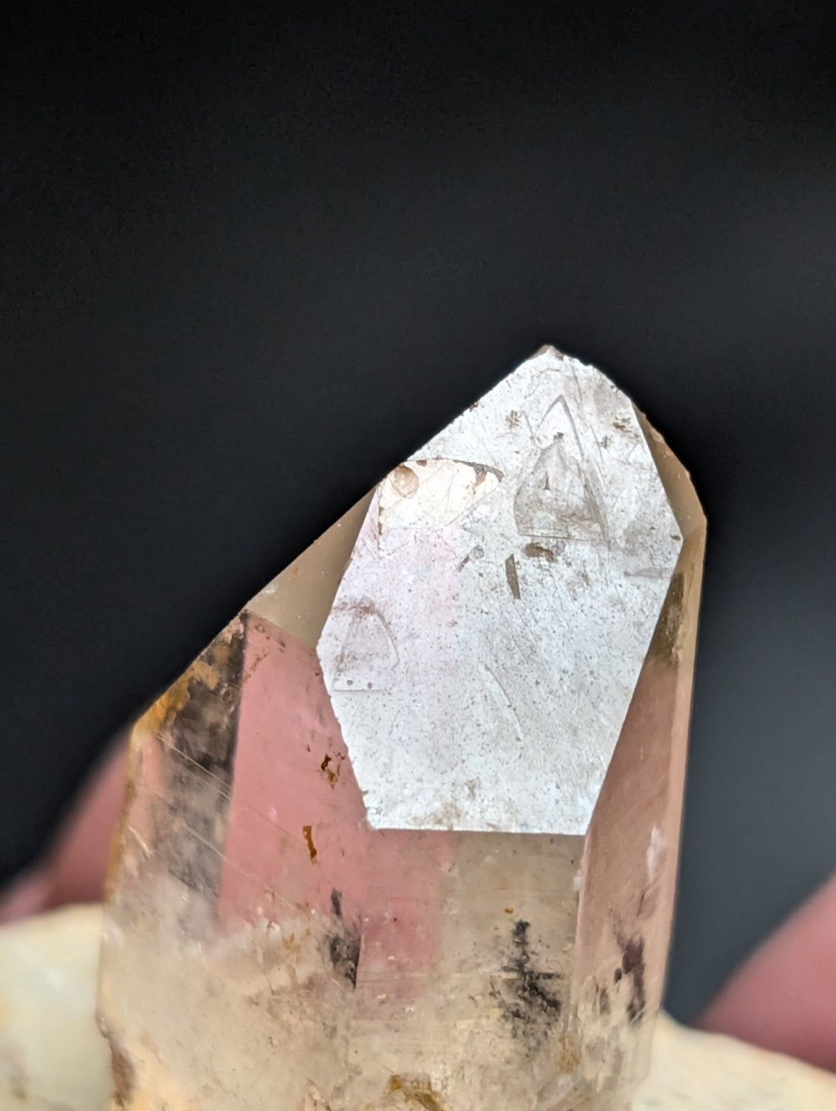 A translucent, pale yellowish quartz crystal with a pointed tip and visible internal inclusions.