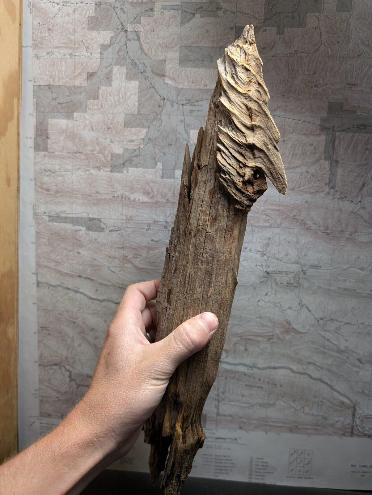 A handcrafted driftwood sculpture of a horse, featuring natural wood grain and weathered brown tones with intricate carved details on its head.