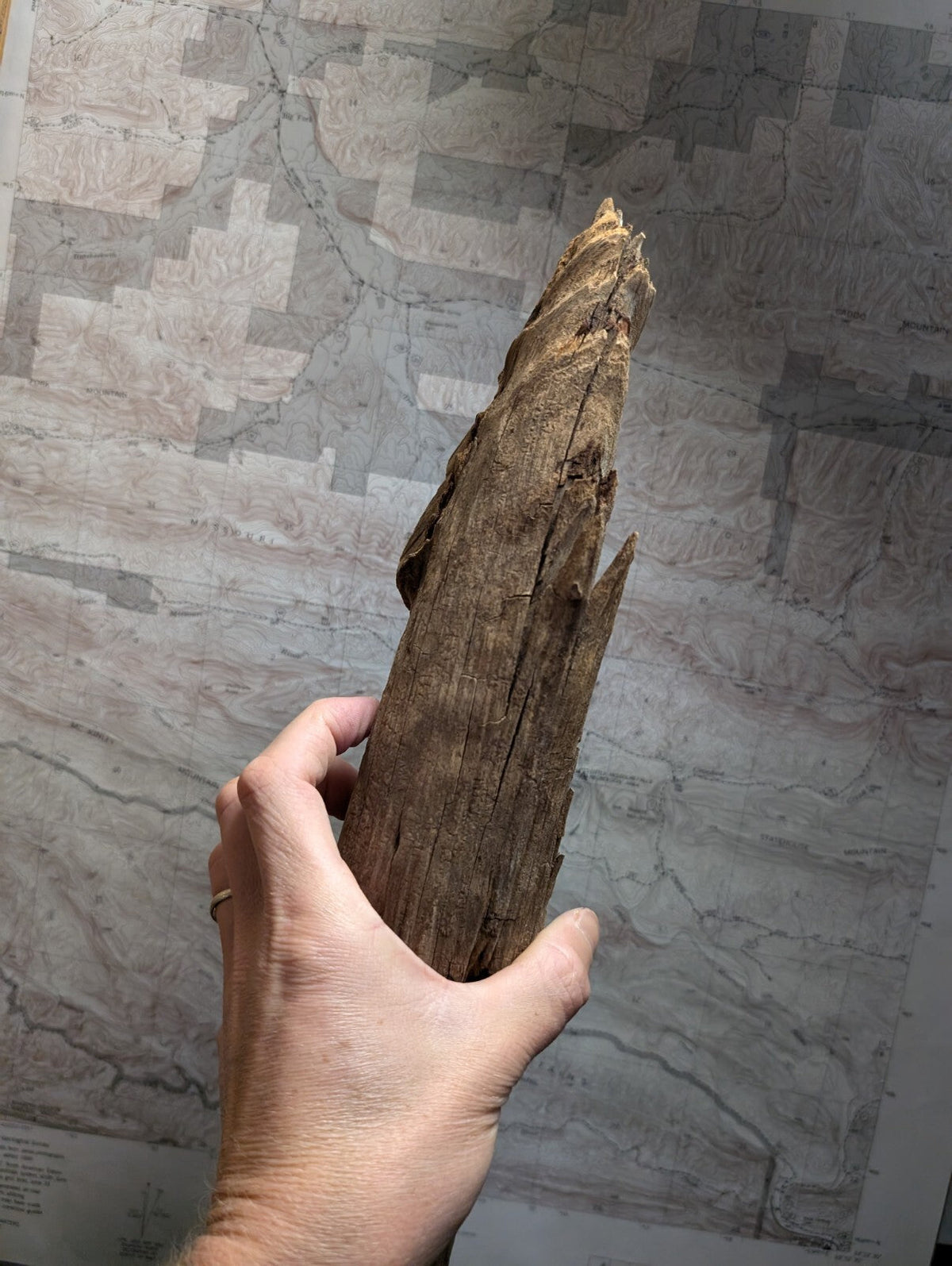 Weathered brown driftwood with a rough, textured surface and natural splits.
