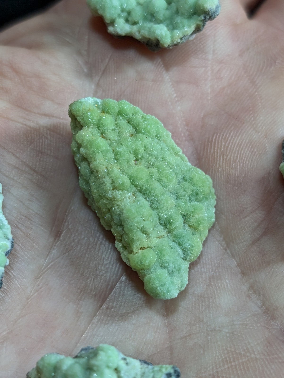 A light green, textured mineral specimen with a rough, crystalline surface.