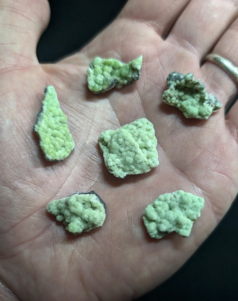Light green, textured mineral specimens with some dark patches.