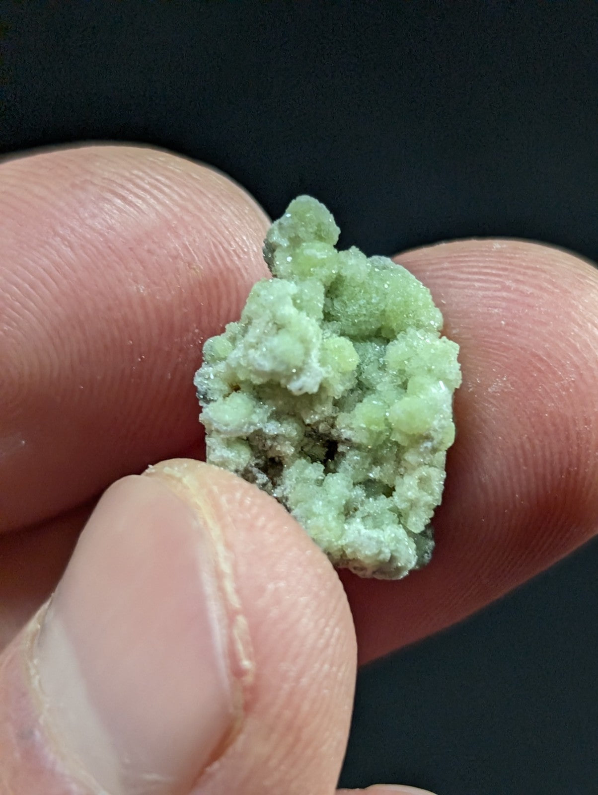 A delicate, light green mineral specimen with a crystalline texture and subtle white veining.