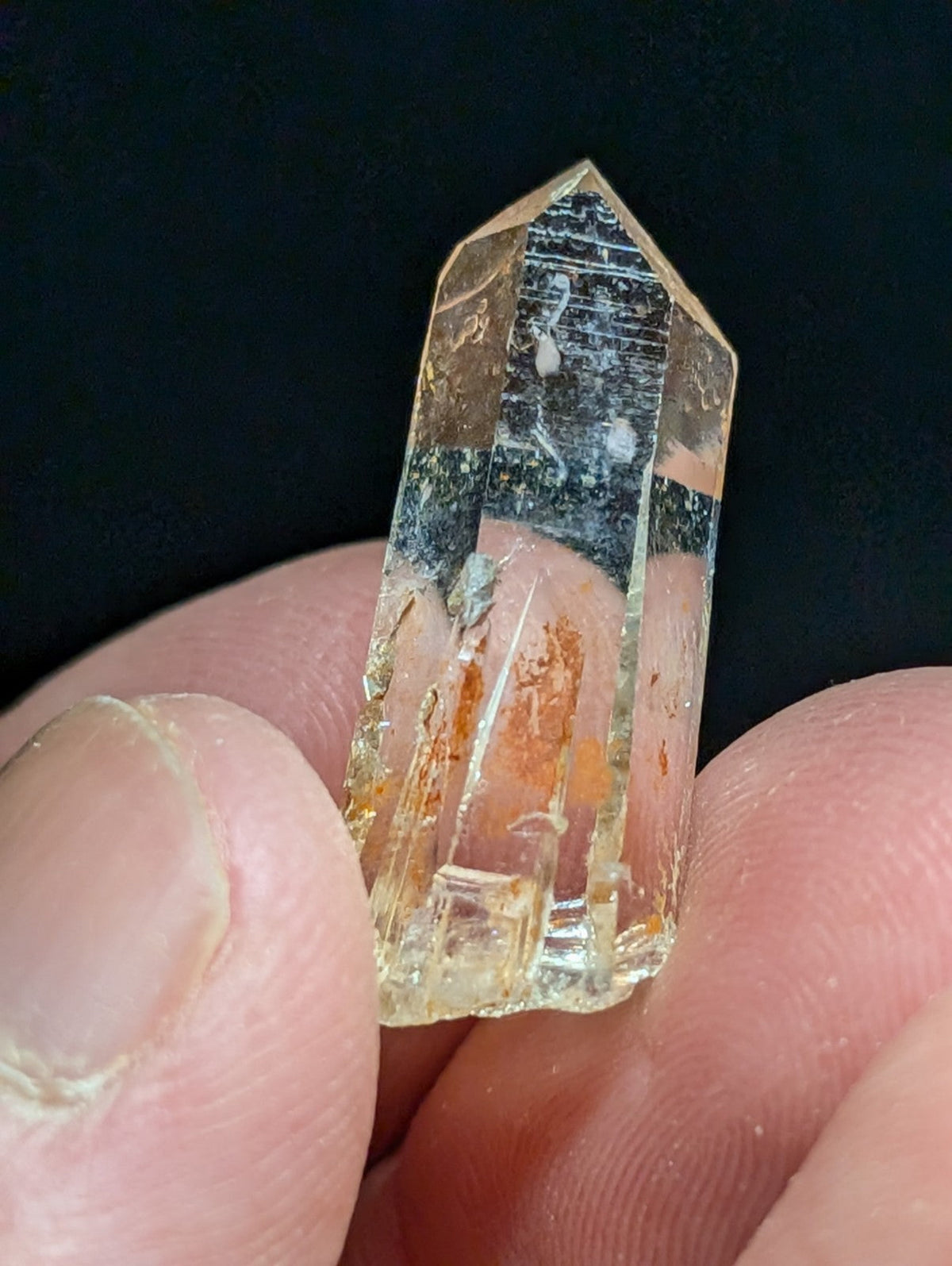 A translucent, amber-hued quartz crystal with natural inclusions and a pointed tip.