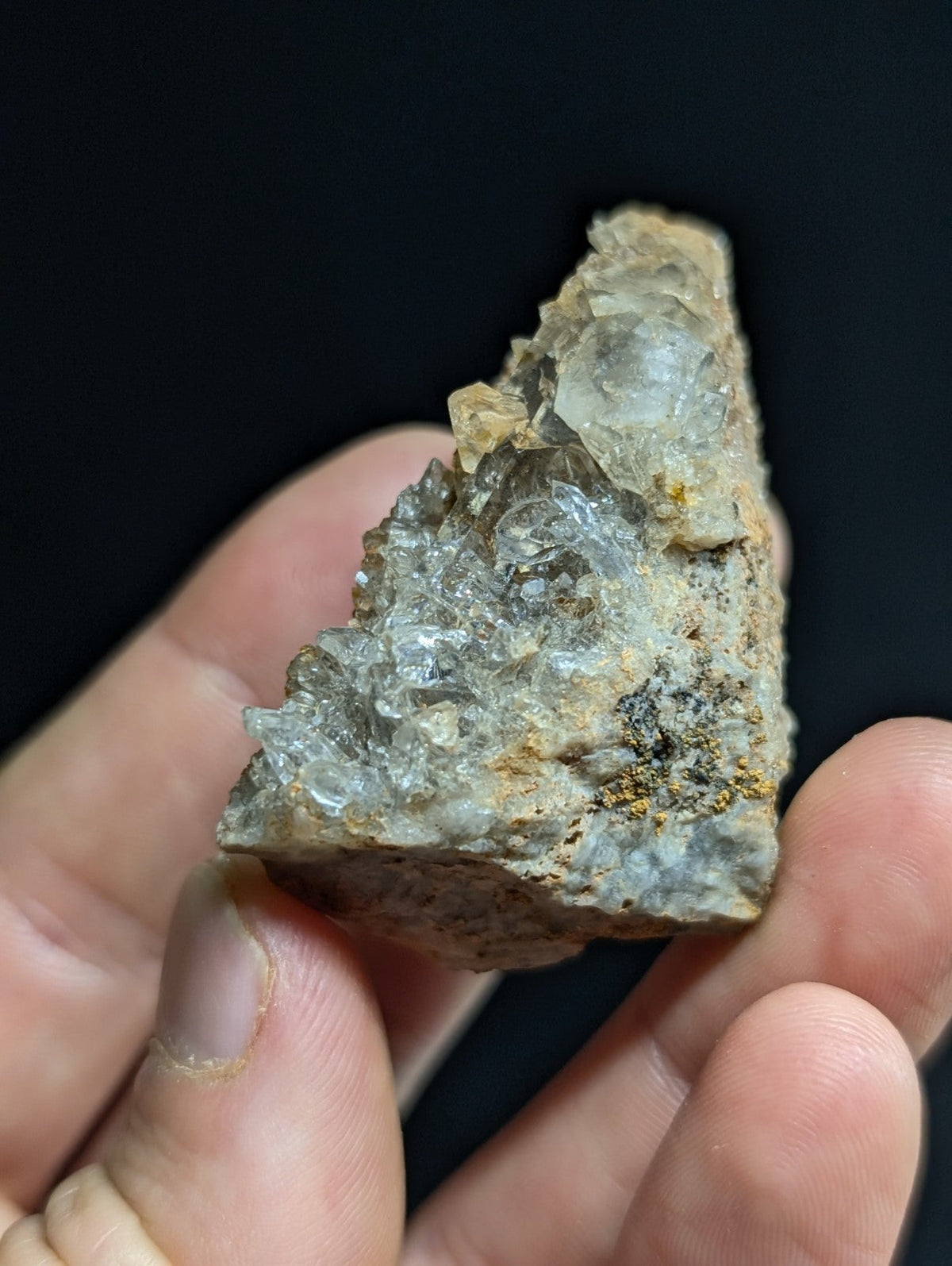 A translucent, crystalline quartz specimen with a rough, earthy matrix and subtle golden mineral inclusions.