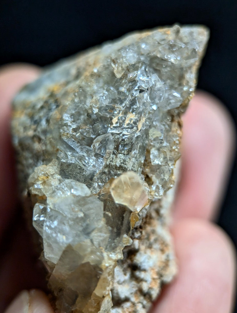 A translucent, crystalline mineral specimen with clear and cloudy quartz formations embedded in a brownish matrix.