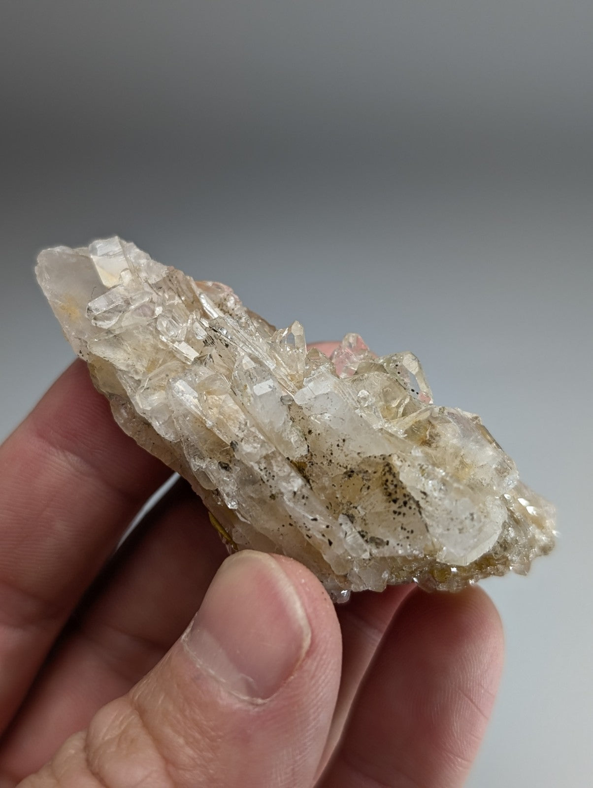 Parallel growth quartz crystal cluster with clear and pale yellow facets and dark specks from saline county arkansas usa