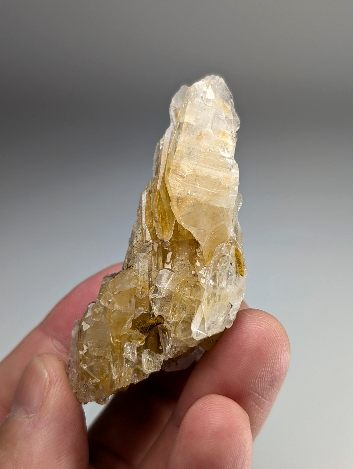 Parallel growth quartz crystal cluster with translucent yellowish faceted formations and rough earthy base from Arkansas USA