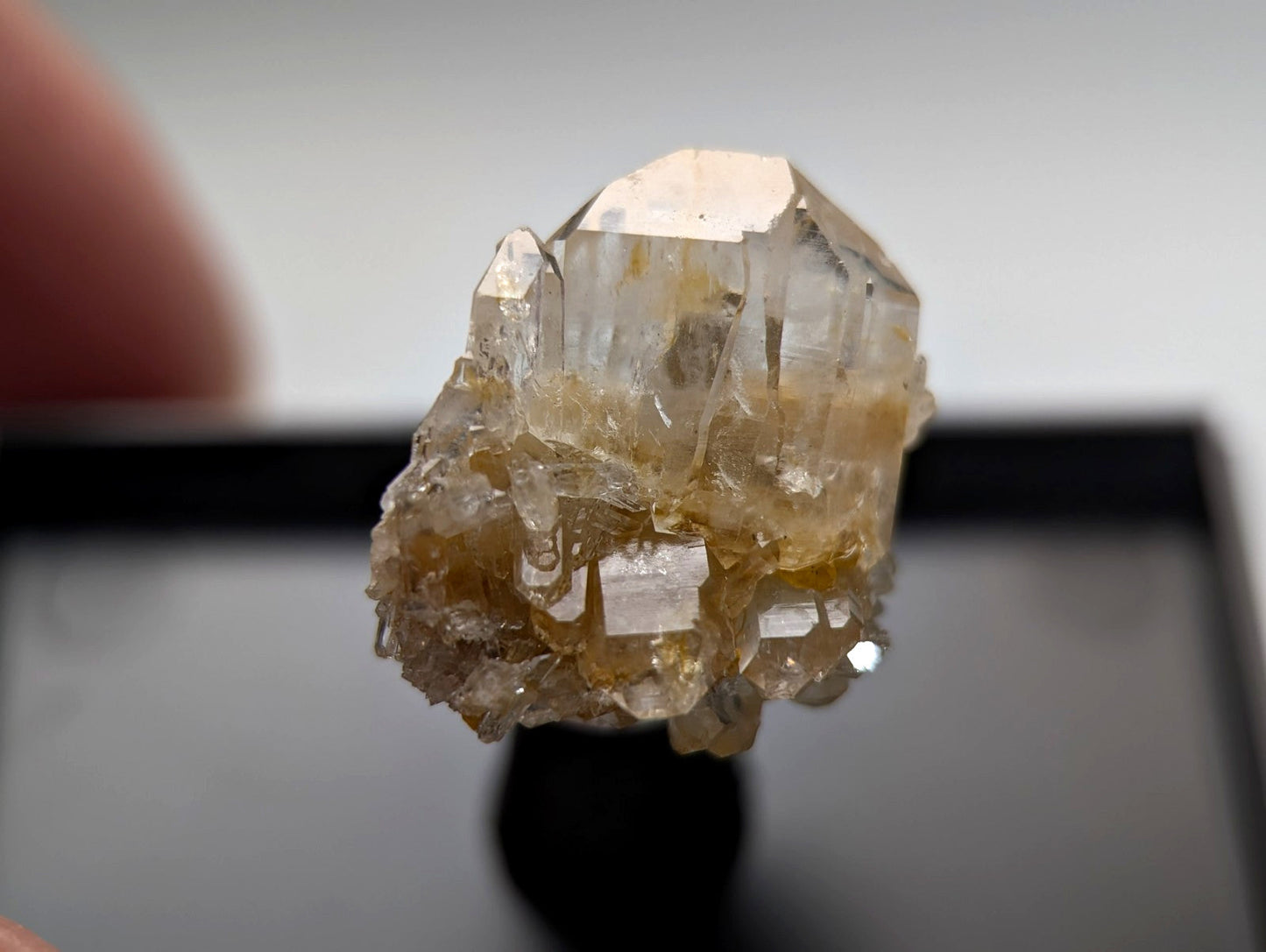 A translucent, golden-hued quartz crystal cluster with sharp geometric facets and a rougher base.