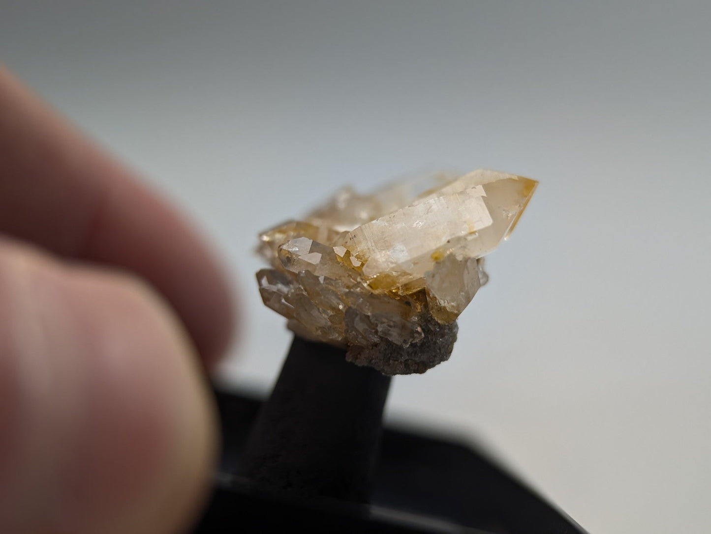A translucent, golden-hued quartz crystal cluster with sharp facets and a rougher base.