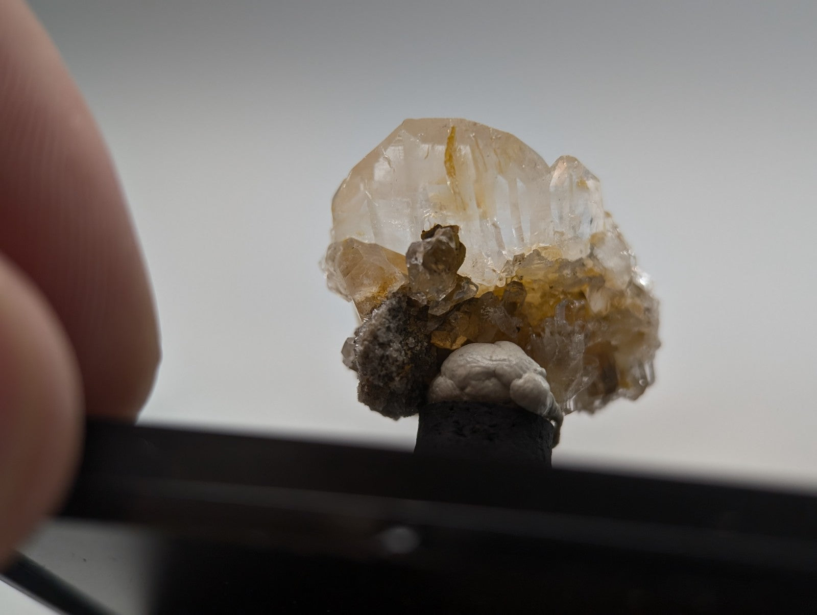 A translucent, amber-hued crystal cluster with jagged edges and embedded darker mineral inclusions.