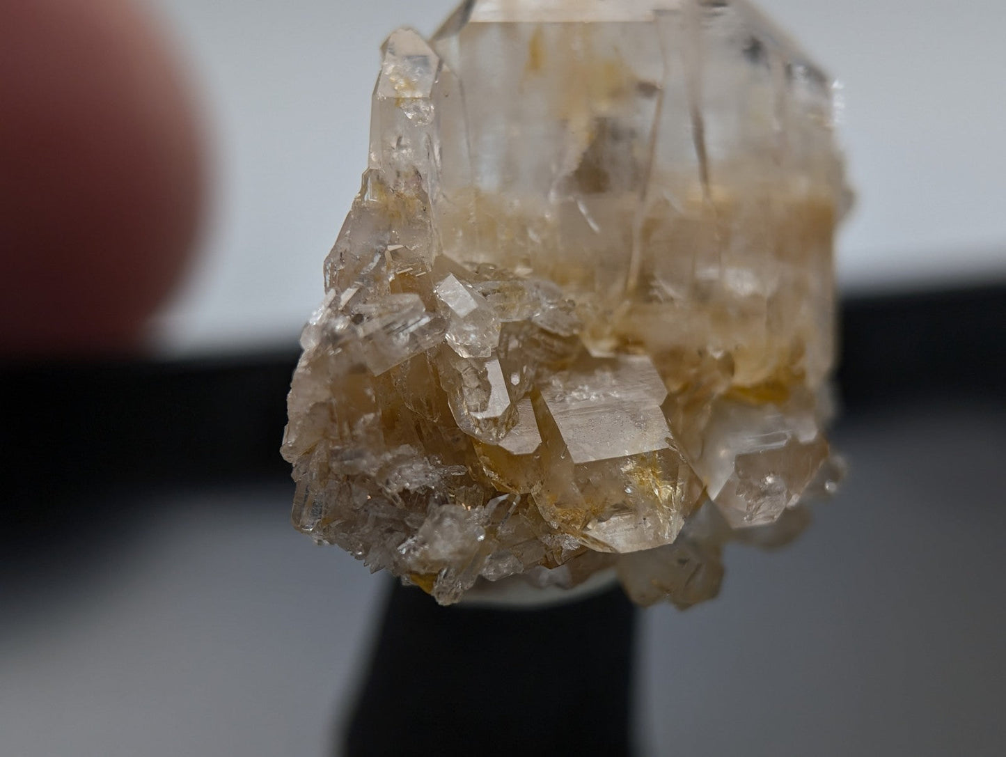 A translucent, golden-hued crystal cluster with sharp geometric facets and a natural, earthy base.