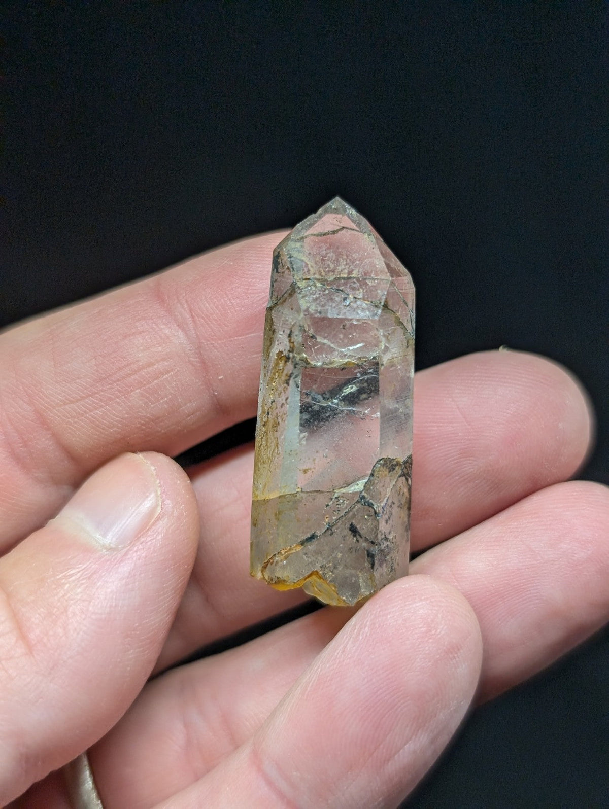 A translucent, pale yellowish quartz crystal with natural inclusions and a pointed tip.