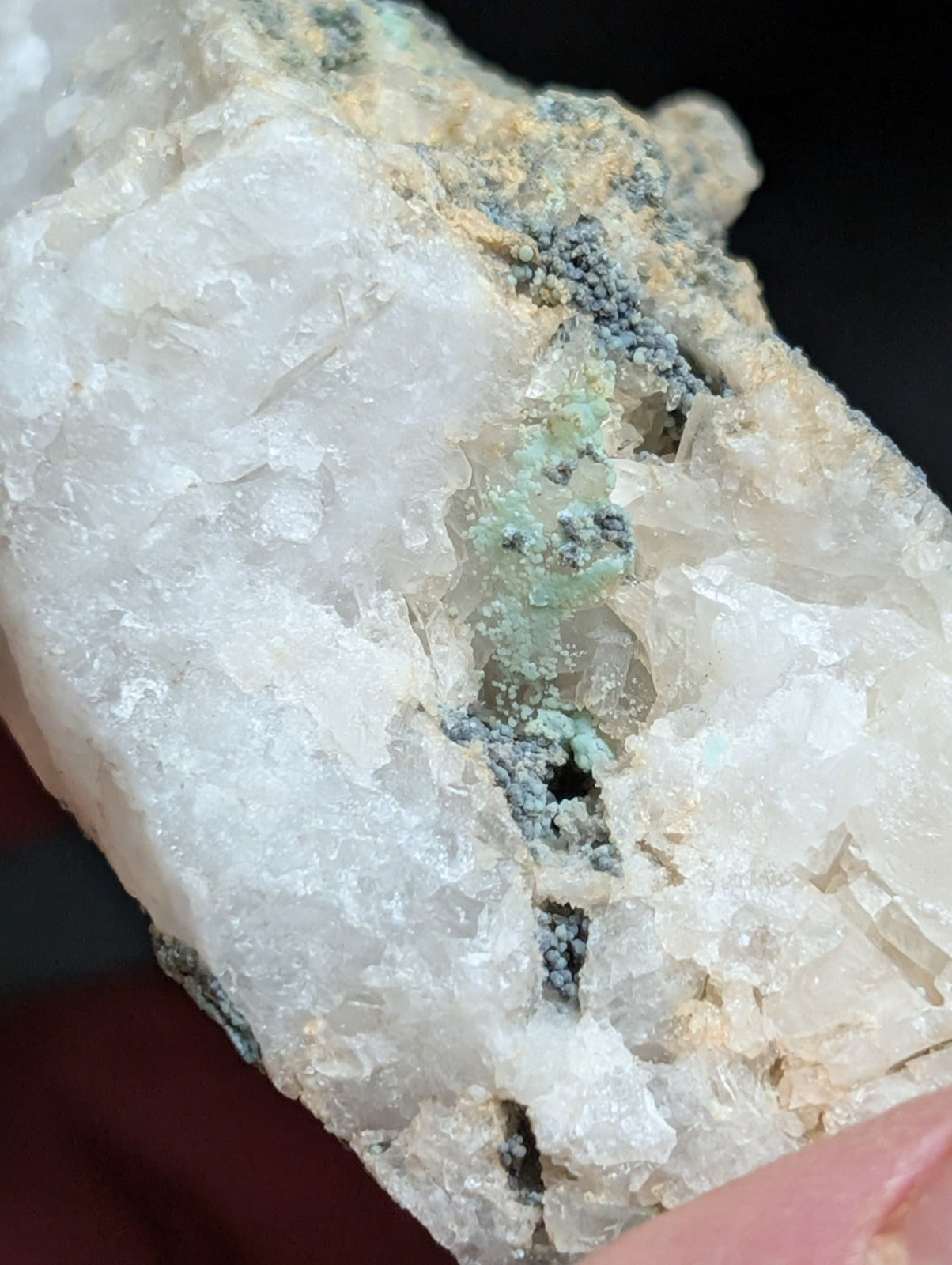 A translucent white quartz crystal formation with embedded greenish-blue mineral inclusions.