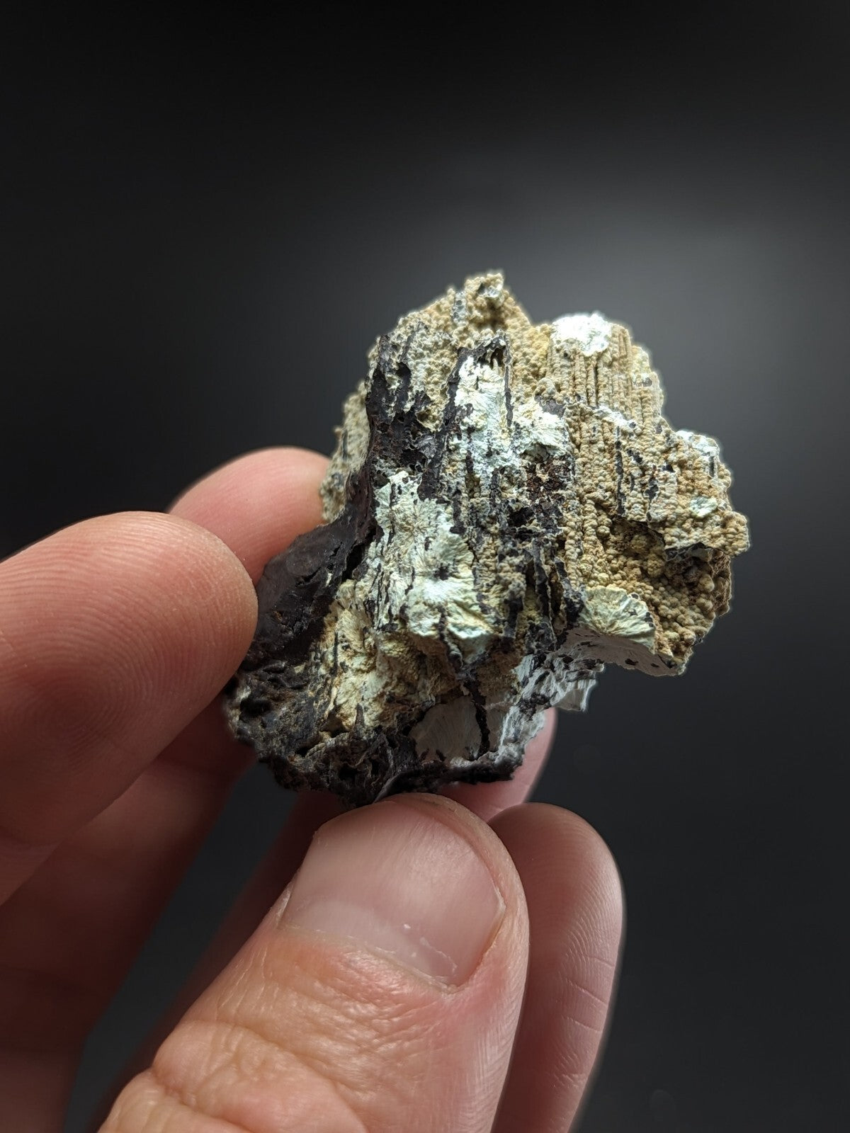 A rugged, irregularly shaped mineral specimen with a mix of dark gray and metallic silver patches.