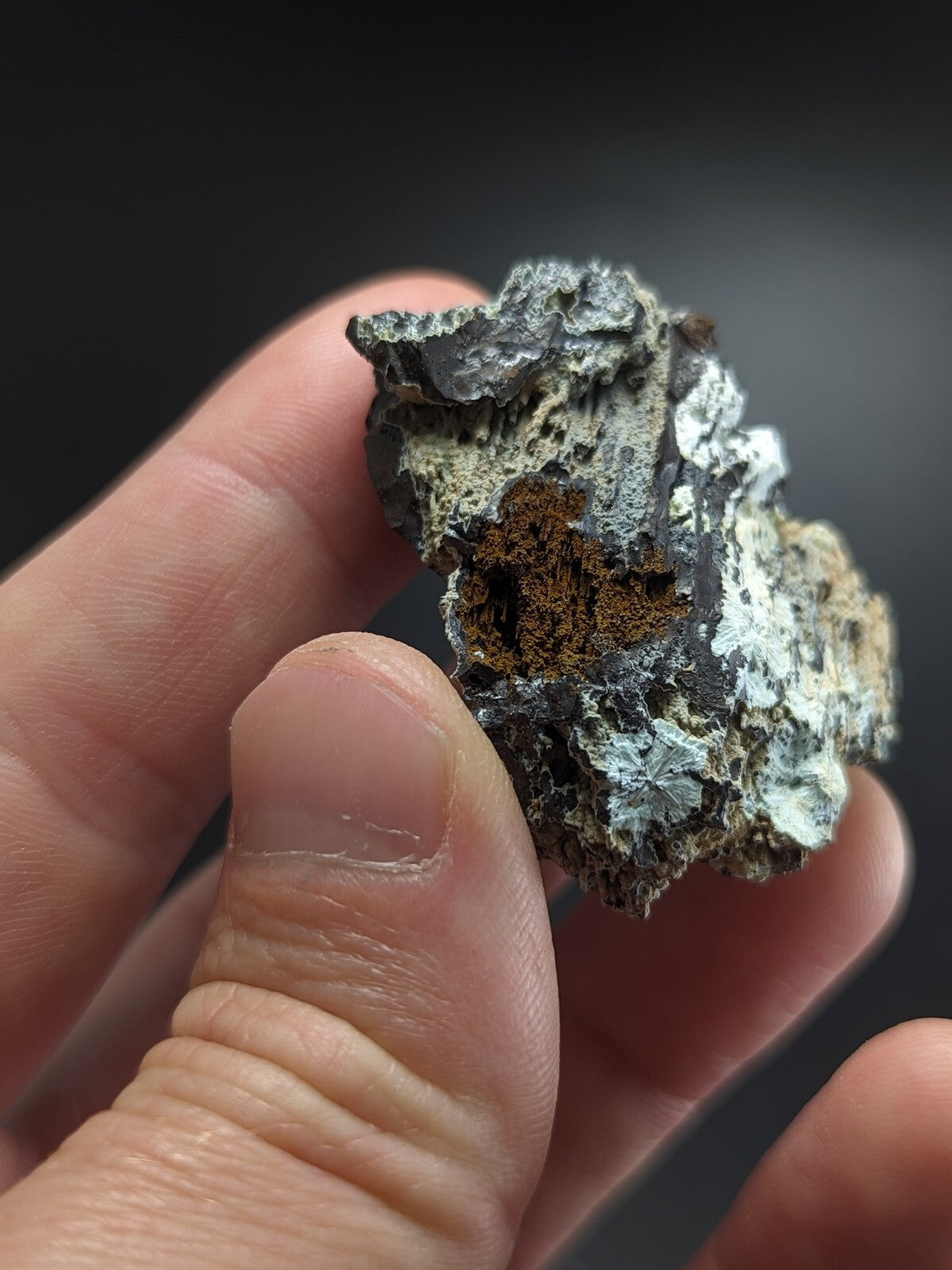 A rugged, irregularly shaped mineral specimen with a mix of gray and brown hues, featuring rough, textured surfaces.