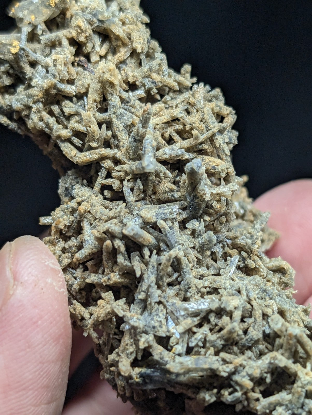 A textured, grayish-green mineral specimen with intricate crystalline formations.