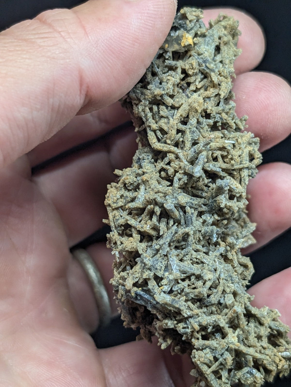 A textured, greenish-gray mineral specimen with intricate crystalline formations.