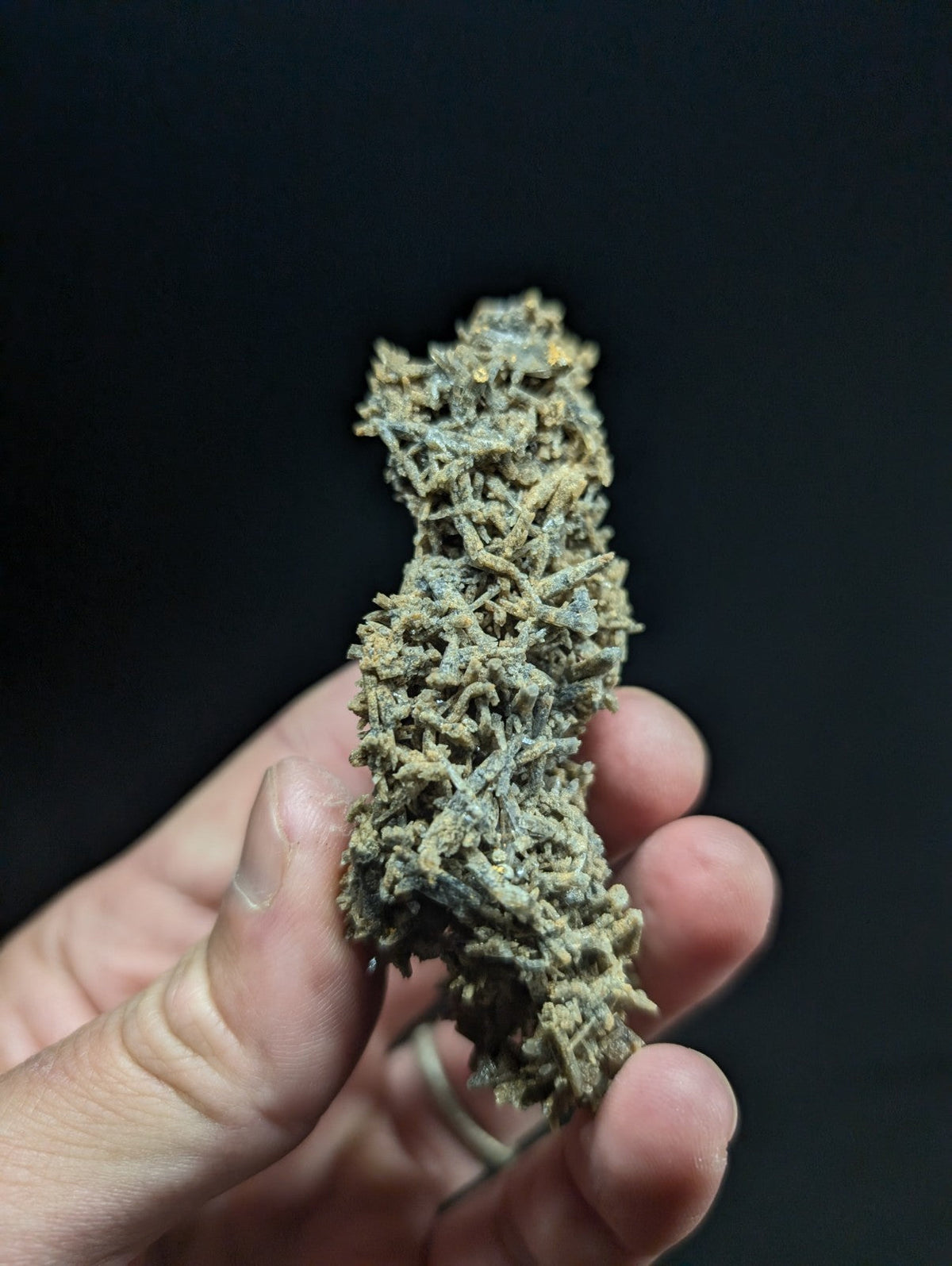 A dense, textured cannabis bud with a mix of green and brown hues.