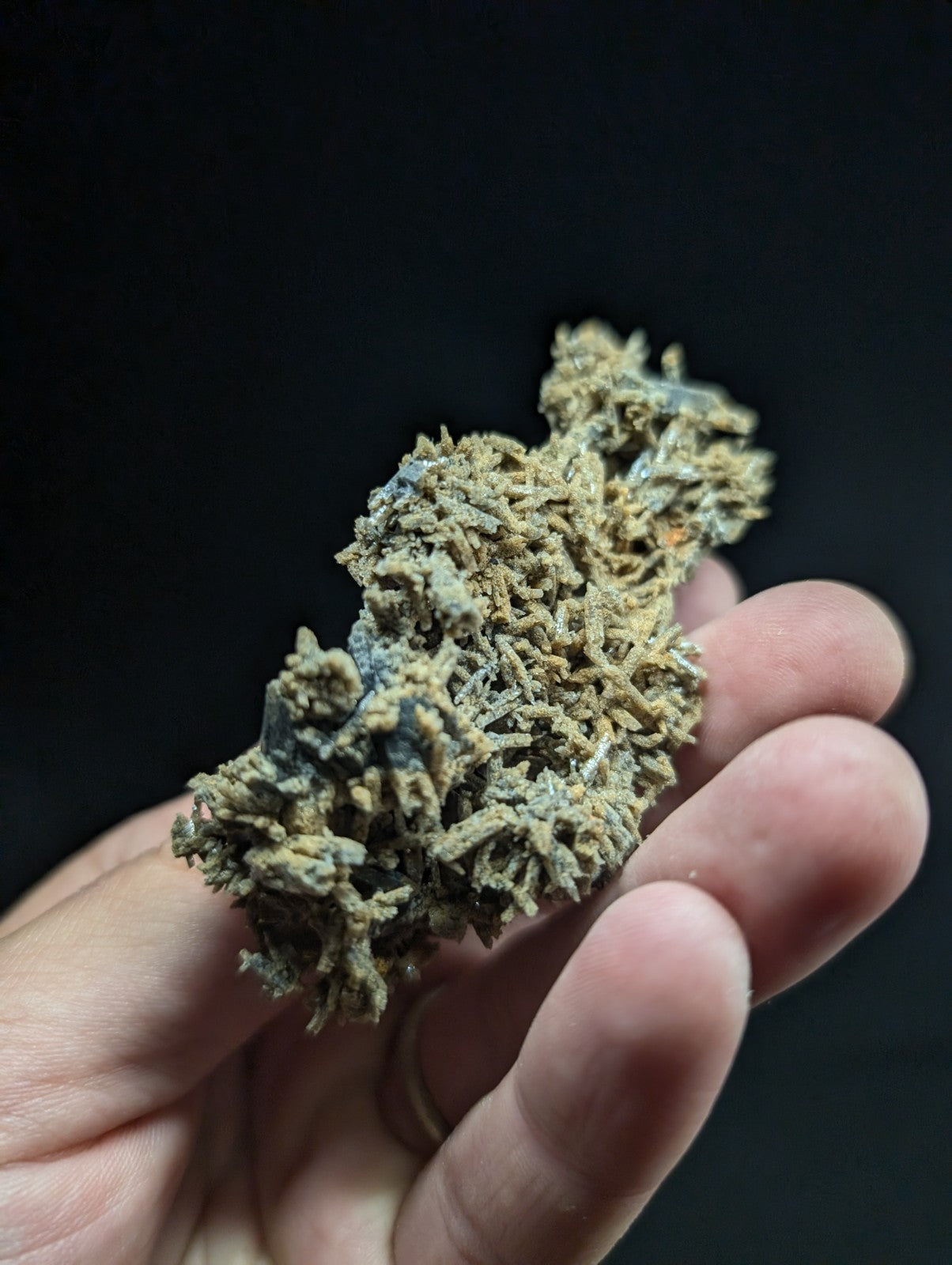 A textured, mossy-green mineral specimen with intricate branching structures and hints of blue patina.