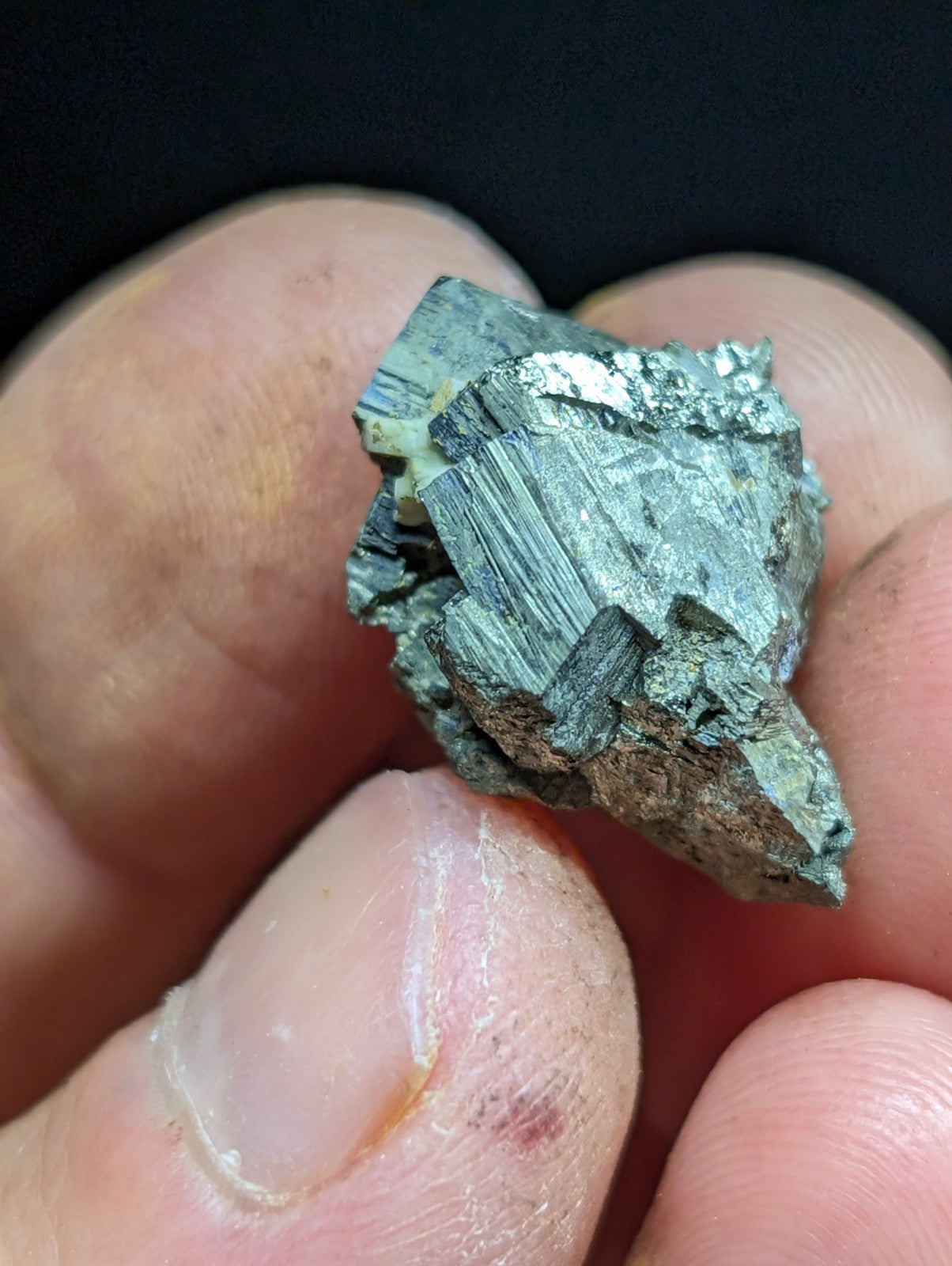 A metallic, jagged mineral specimen with a silvery-gray sheen and visible crystalline facets.