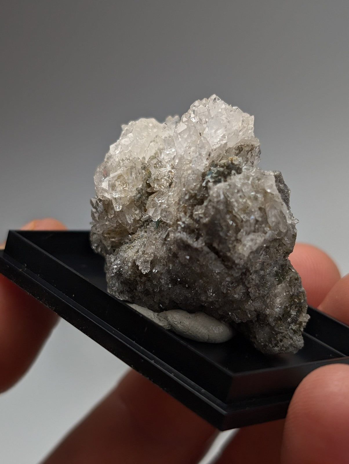 Quartz crystal cluster with blue-green cookeite in translucent clear and gray hues on black base from saline county arkansas