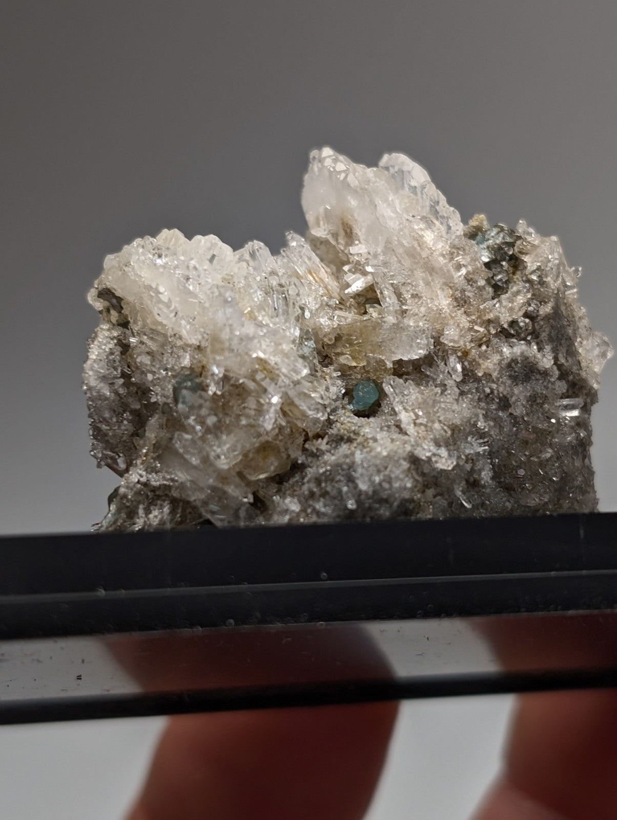 Quartz crystal cluster with blue-green cookeite featuring translucent grayish hues and embedded green gemstones from Arkansas