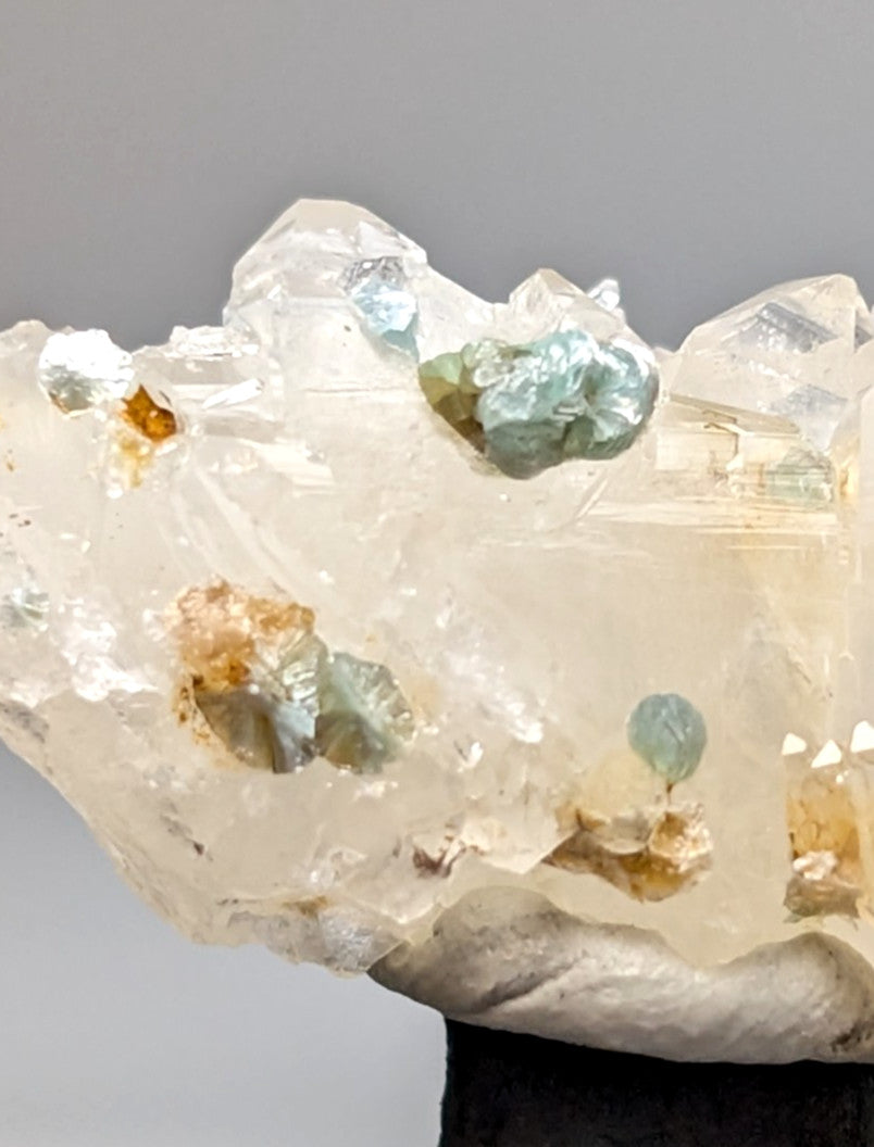 Quartz crystal cluster with blue-green cookeite and amber mineral inclusions from Saline County Arkansas under UV light