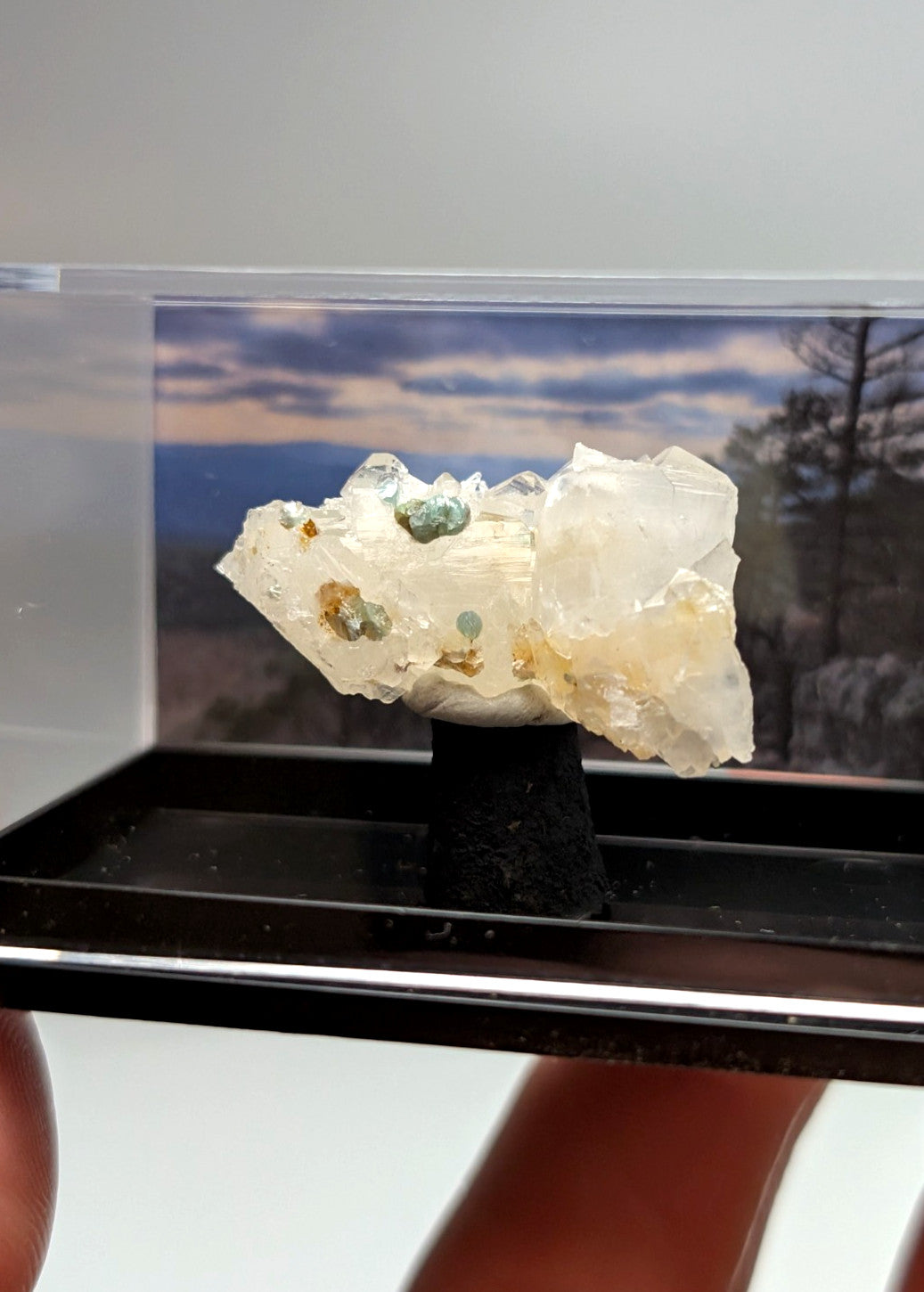 Quartz crystal cluster with blue-green cookeite featuring translucent mineral and green yellow inclusions on black stand