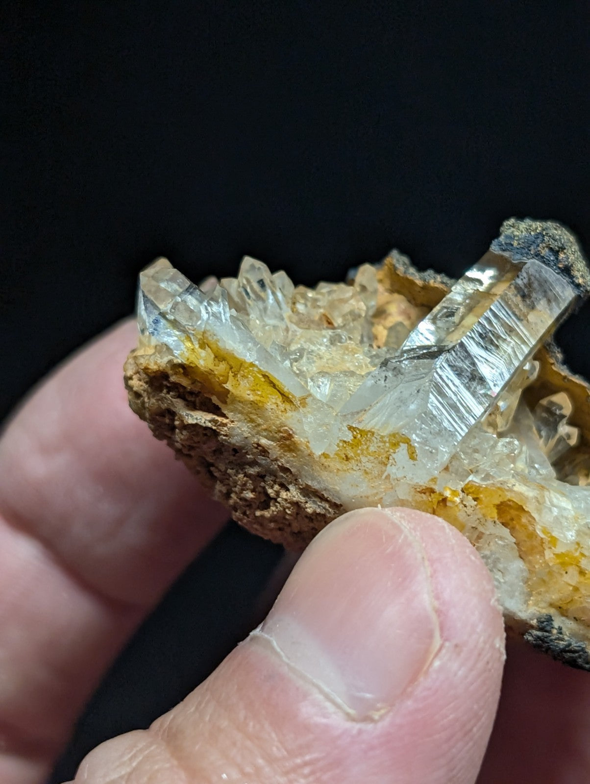 A translucent, crystalline quartz cluster with sharp facets and a golden-yellow matrix.