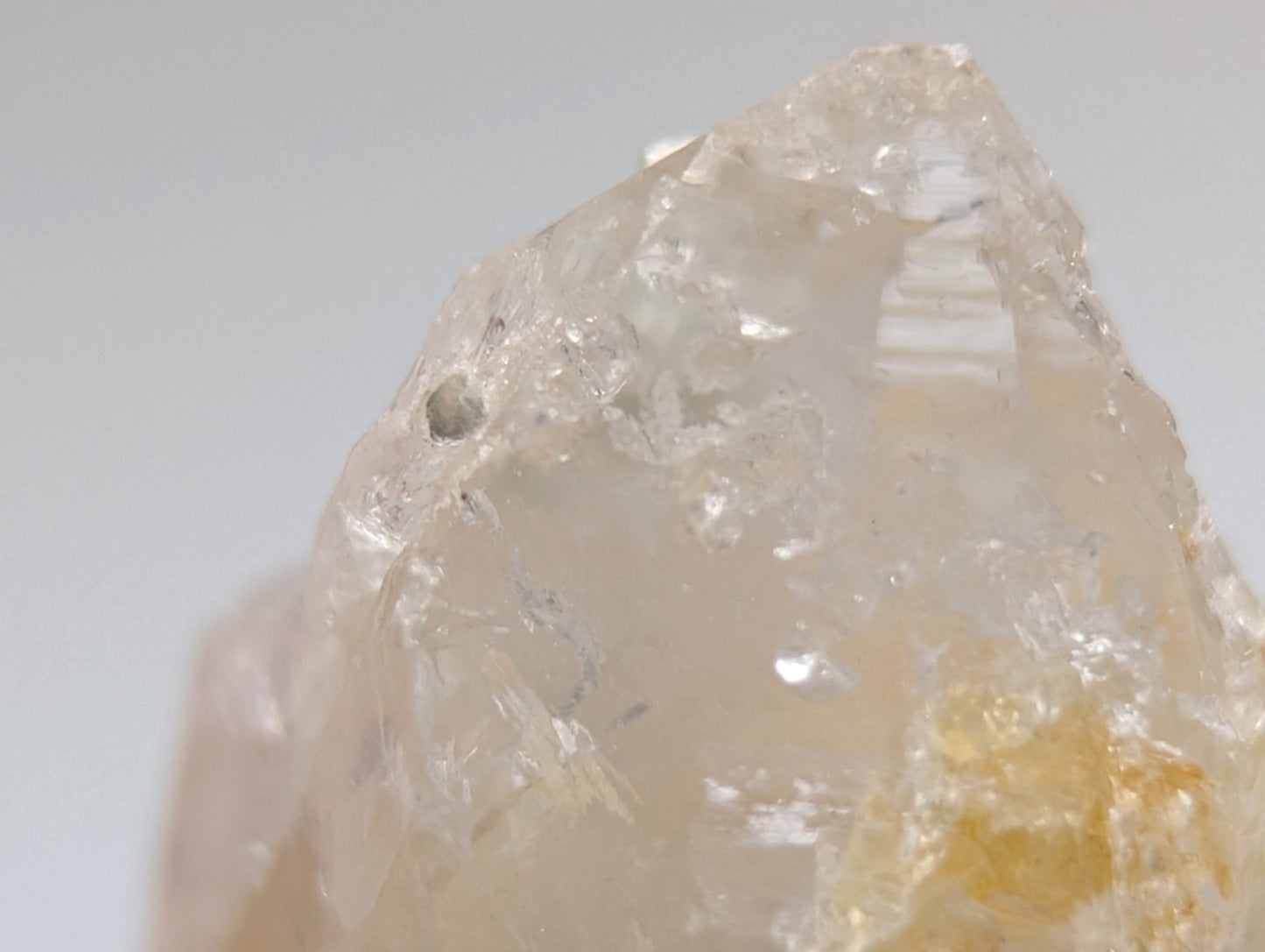 Quartz crystal point with UV reactive cookeite, pale yellow translucent quartz with rough faceted surface from Arkansas USA