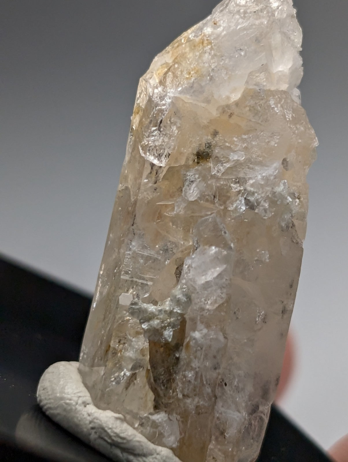 A translucent pale yellow quartz crystal point with rough facets and internal inclusions from saline county arkansas