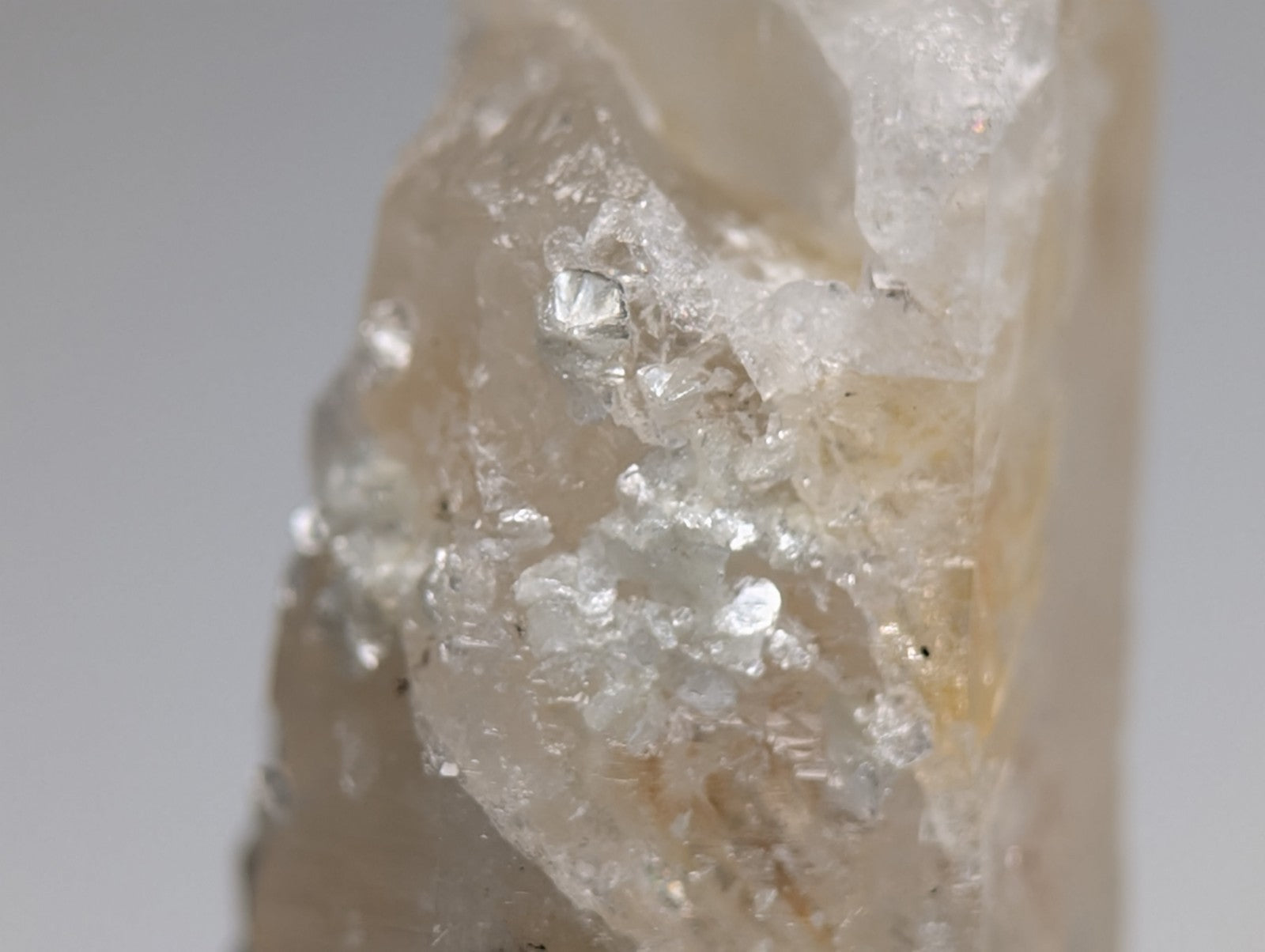 Quartz crystal point with uv reactive cookeite showing pale yellow translucent quartz and clear mineral inclusions