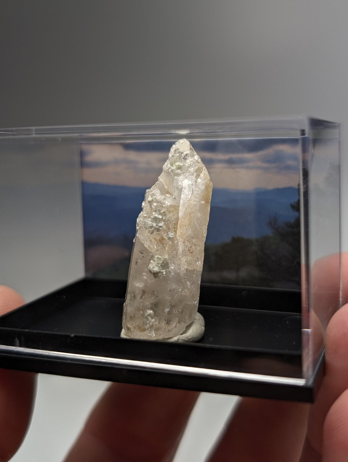 Quartz crystal point with uv reactive cookeite from saline county arkansas showing translucent pale color and natural surface