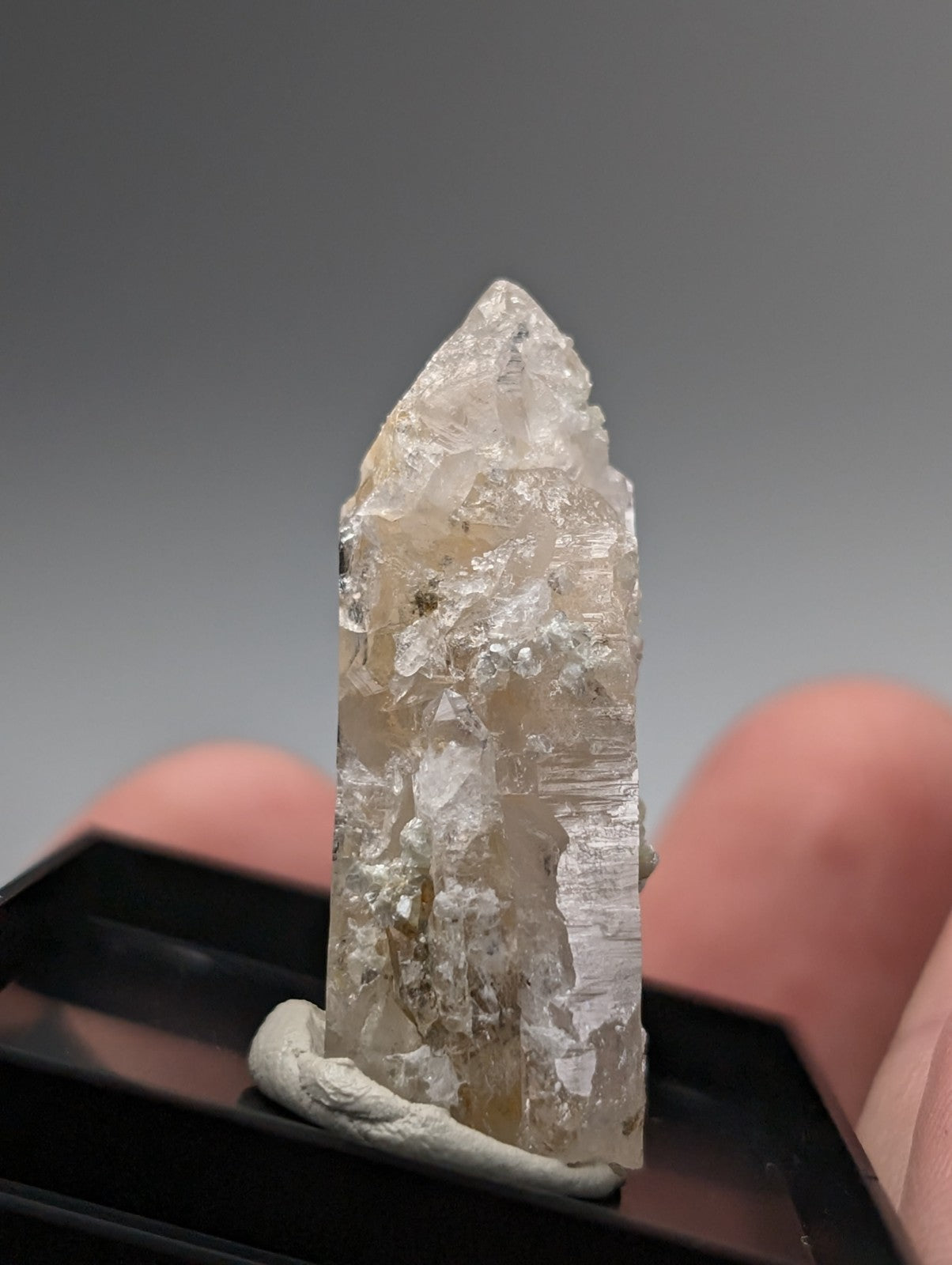 Translucent pale quartz crystal point with uv reactive cookeite and visible internal inclusions from arkansas usa