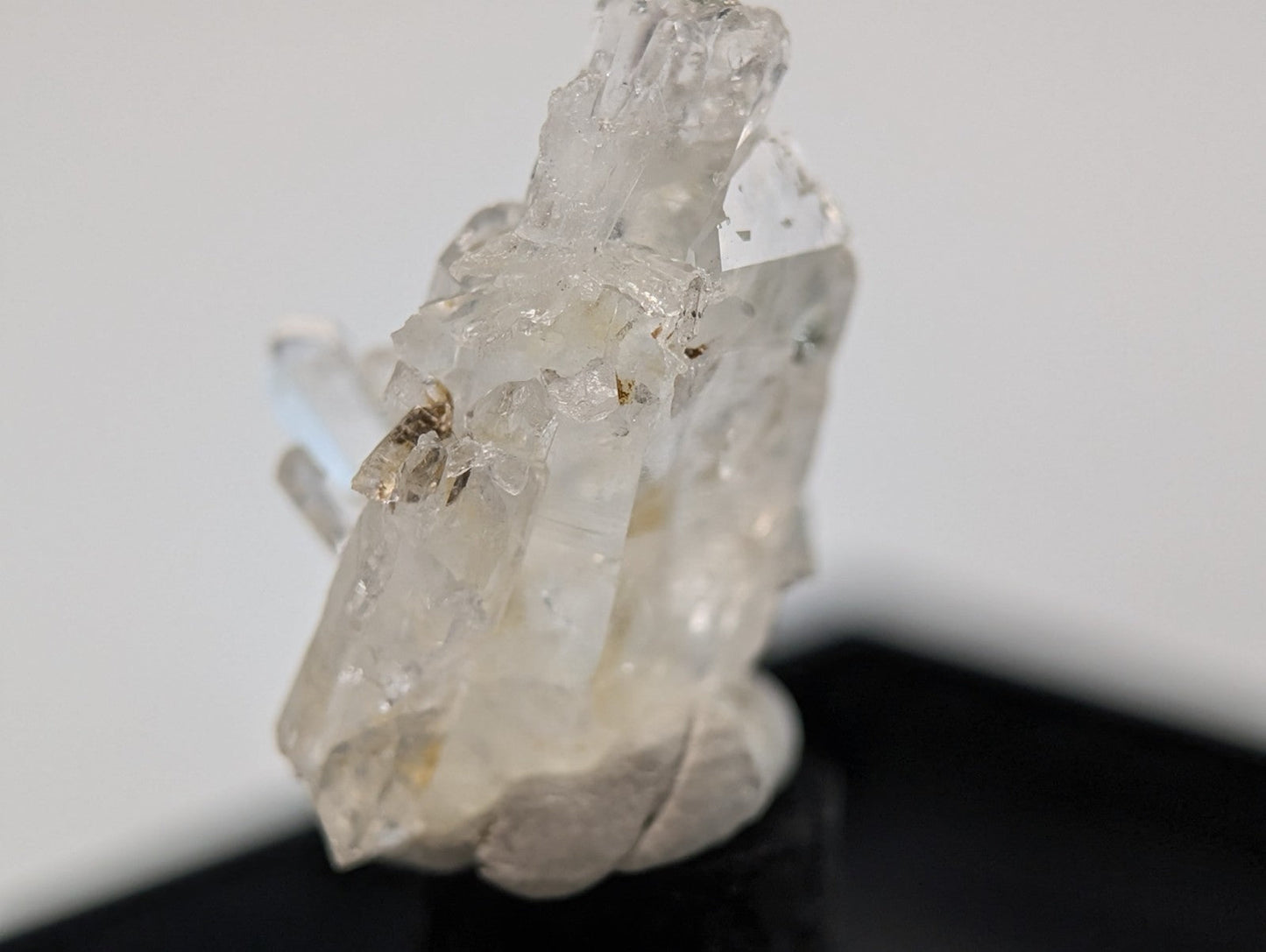 A translucent, clear quartz crystal cluster with jagged edges and natural imperfections.