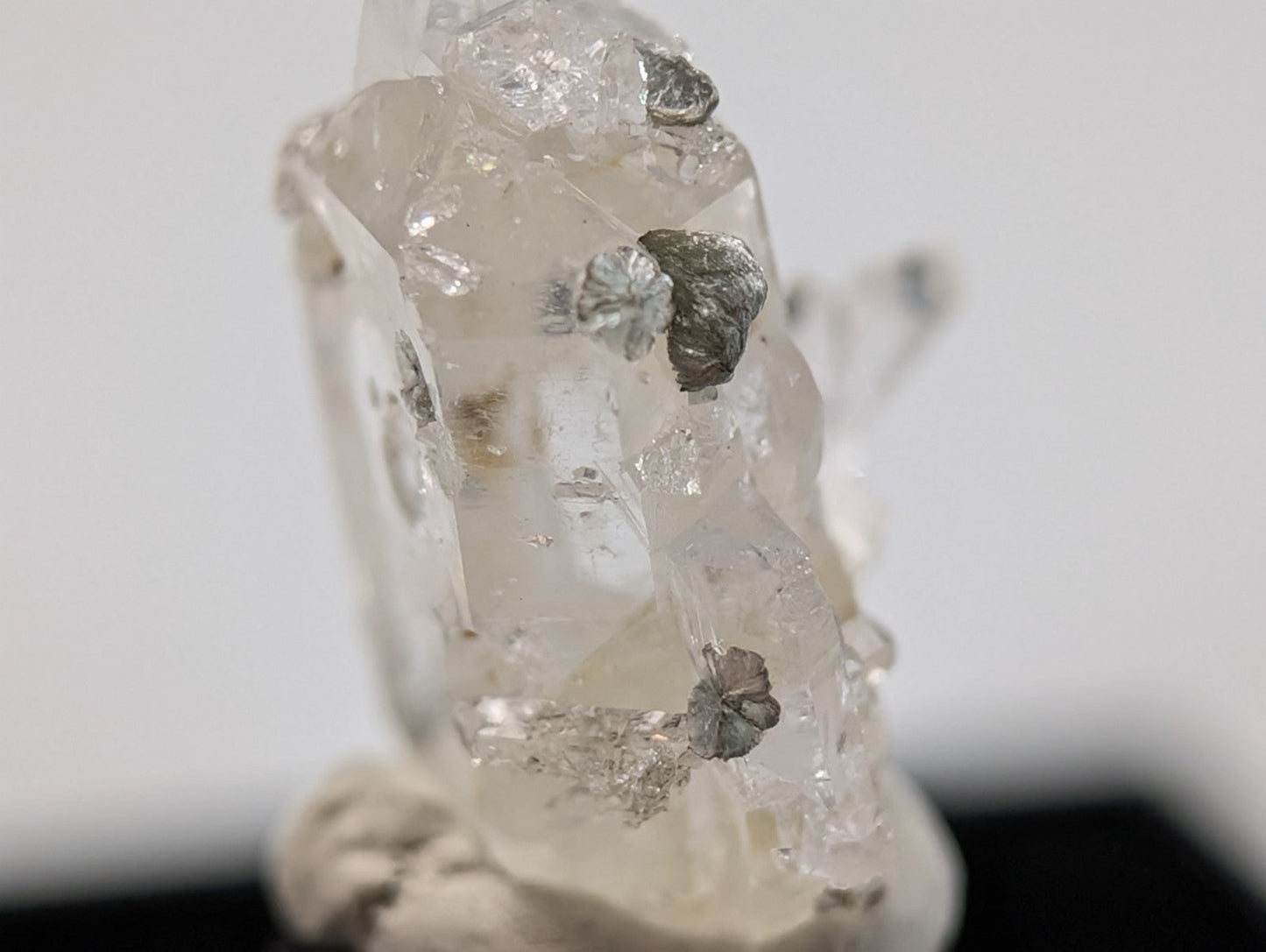 A translucent quartz crystal specimen with embedded metallic silver inclusions.