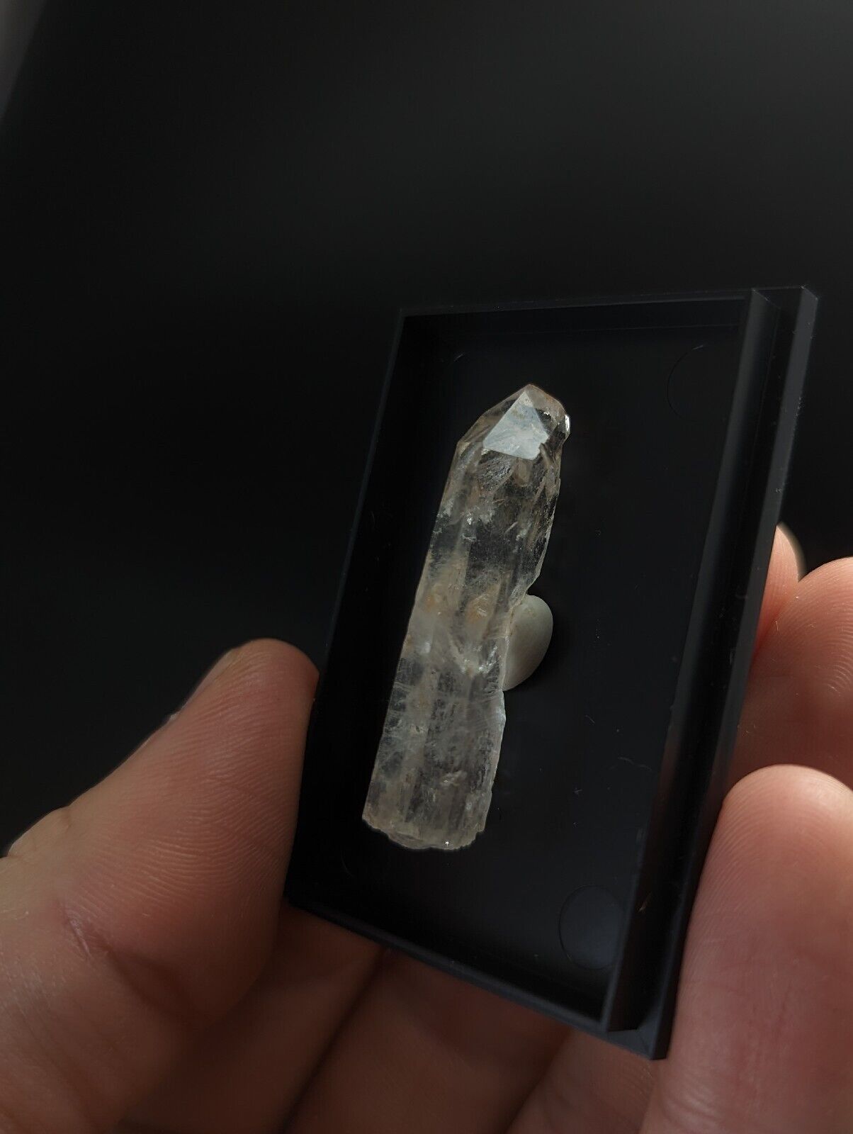 Translucent crystal specimen in a black display box.