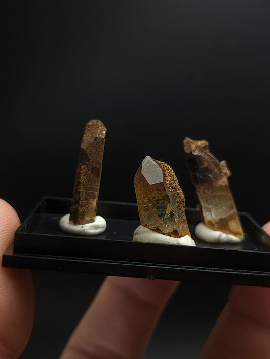 Three brown crystal specimens.