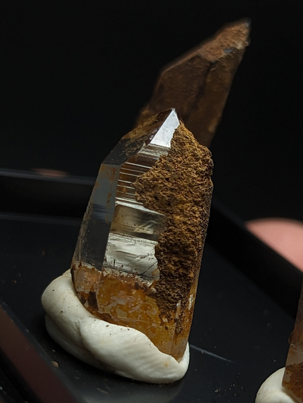 A translucent golden citrine crystal with a rough, earthy brown matrix and metallic sheen.