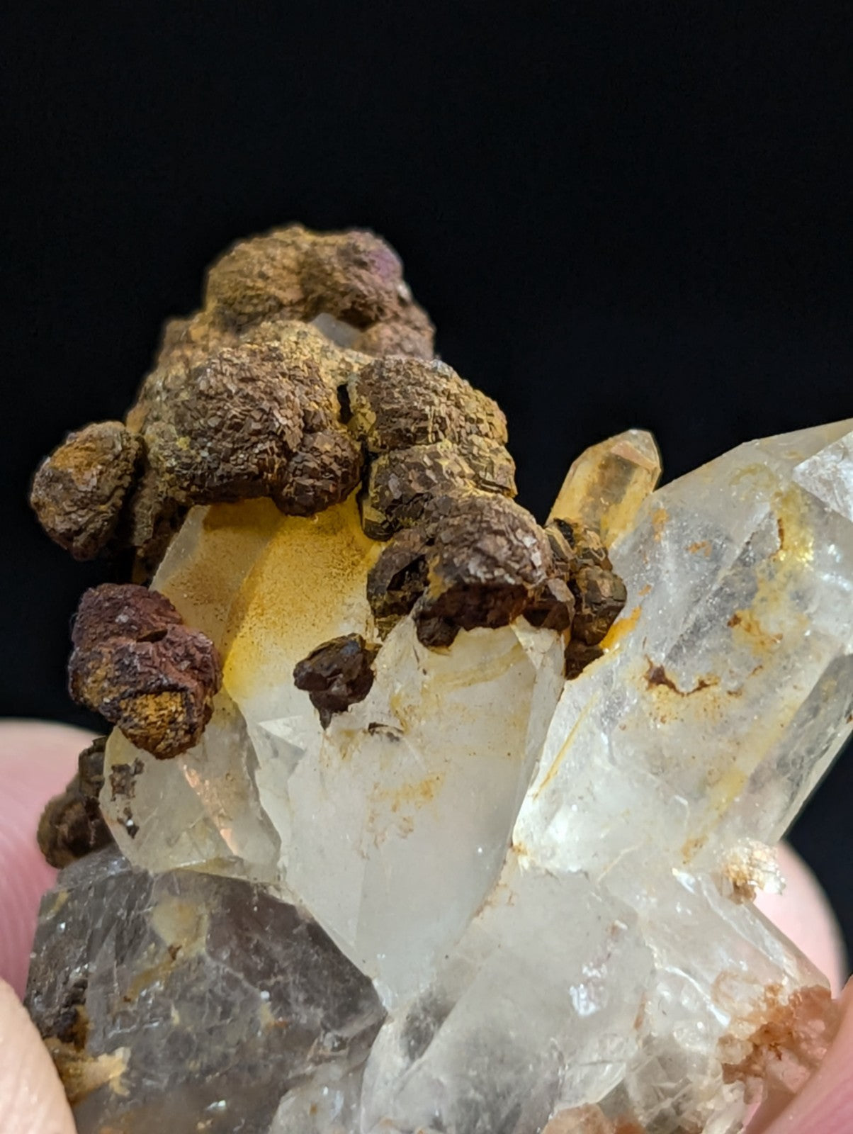 A translucent quartz crystal cluster with golden-yellow inclusions and dark brown, earthy matrix material.