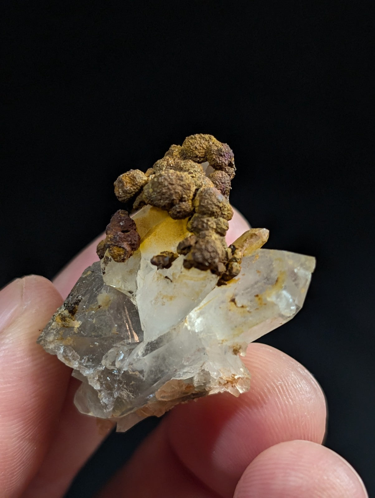 A translucent quartz crystal cluster with earthy brown and yellow mineral inclusions.