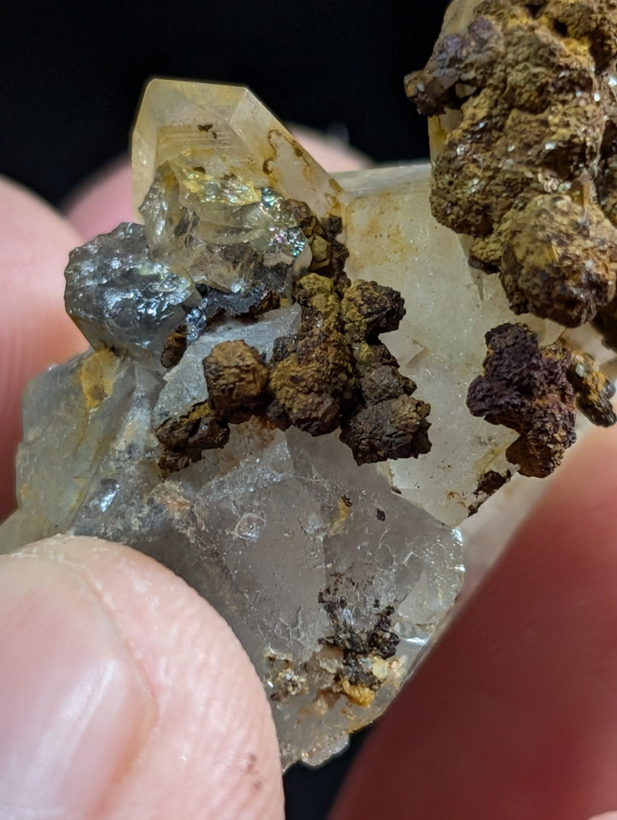 A translucent, crystalline mineral specimen with embedded dark brown and black earthy inclusions.