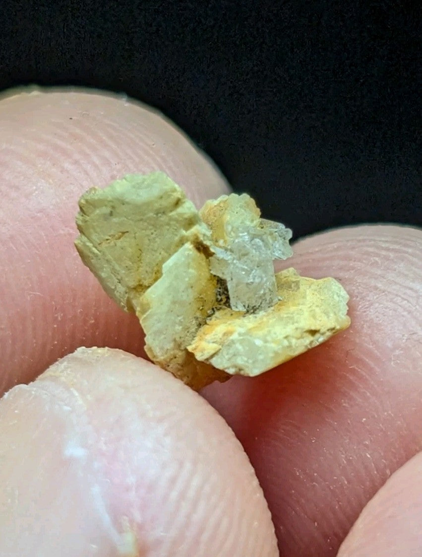 A cluster of yellowish-green mineral crystals with a translucent, glassy appearance.