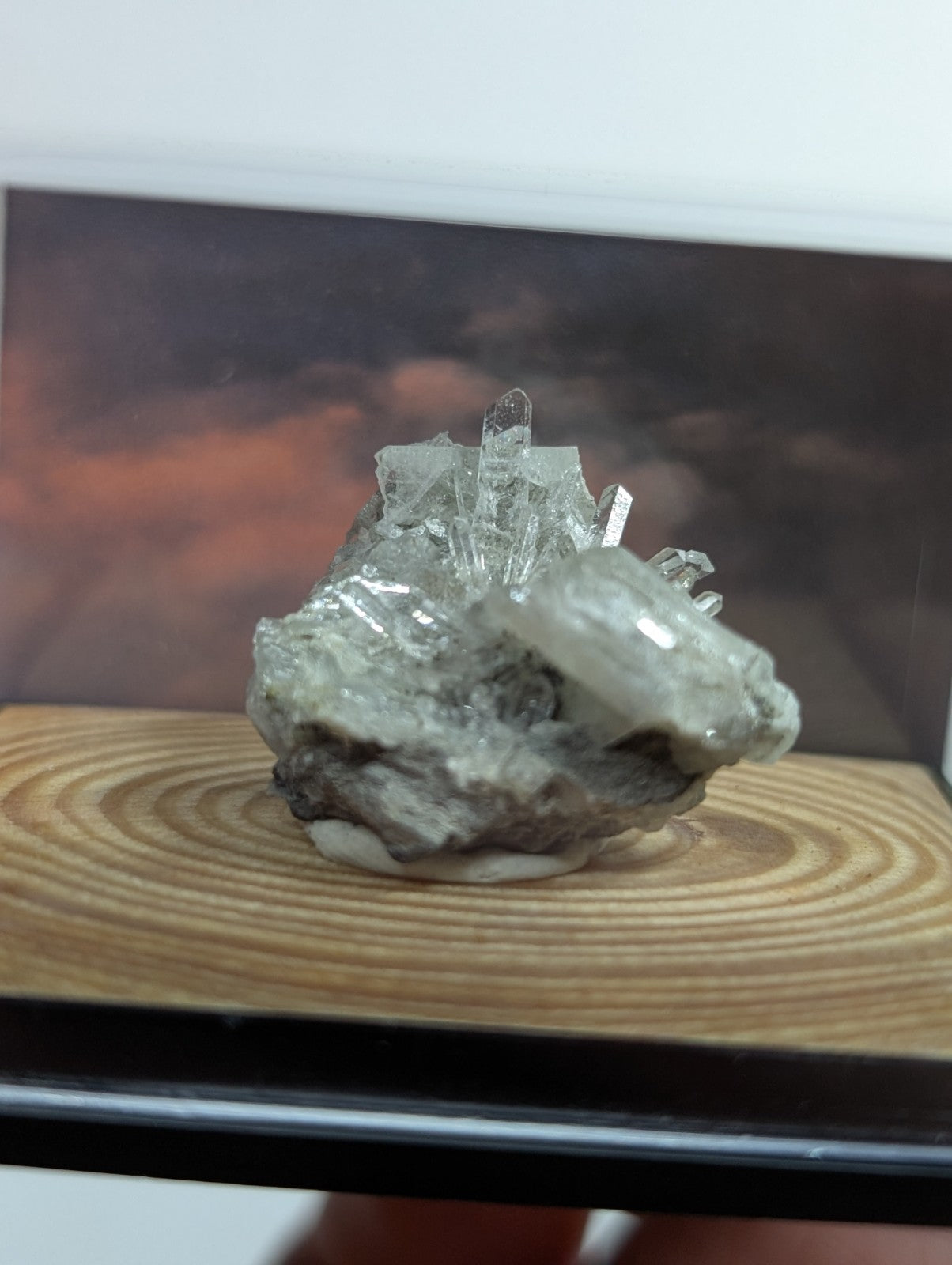 A translucent, clear quartz crystal cluster with sharp facets and a rougher base rock.