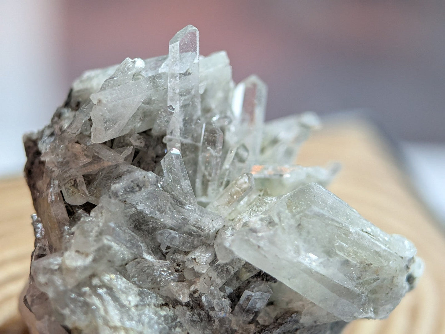 A cluster of translucent, clear quartz crystals with sharp, pointed facets and a slightly grayish tint.