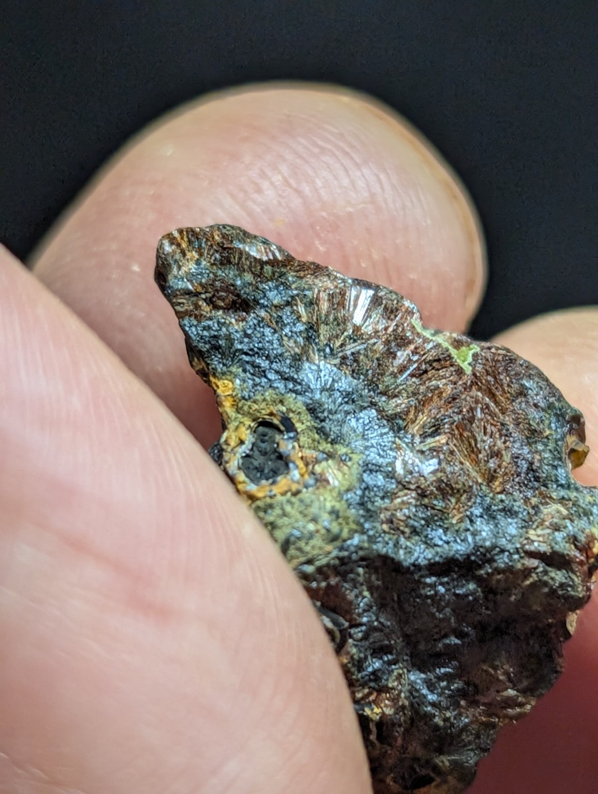 A rugged, irregularly shaped mineral specimen with a mottled surface of dark brown, blue-green patina, and patches of yellowish oxidation.