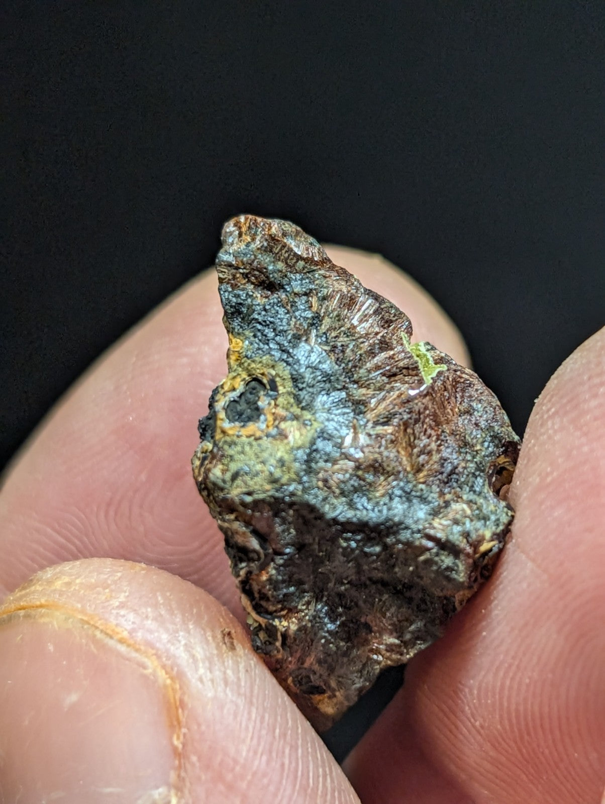 A rugged, irregularly shaped mineral specimen with a mottled surface of dark brown and patches of vibrant blue-green patina.